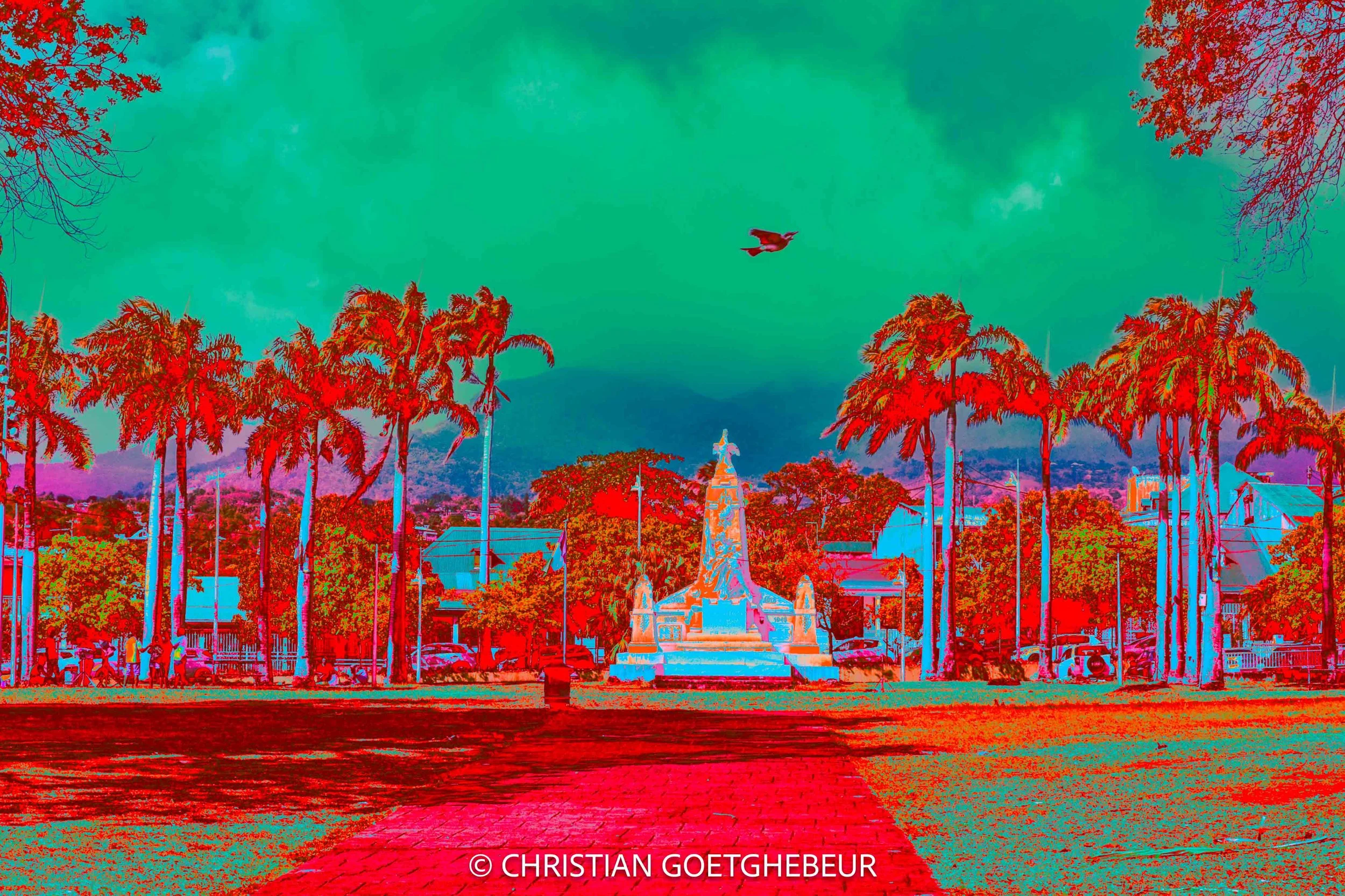 À Basse-Terre, une place s’ouvre entre palmiers et architecture. La couleur en révèle une autre lecture, dans une métamorphose du visible.