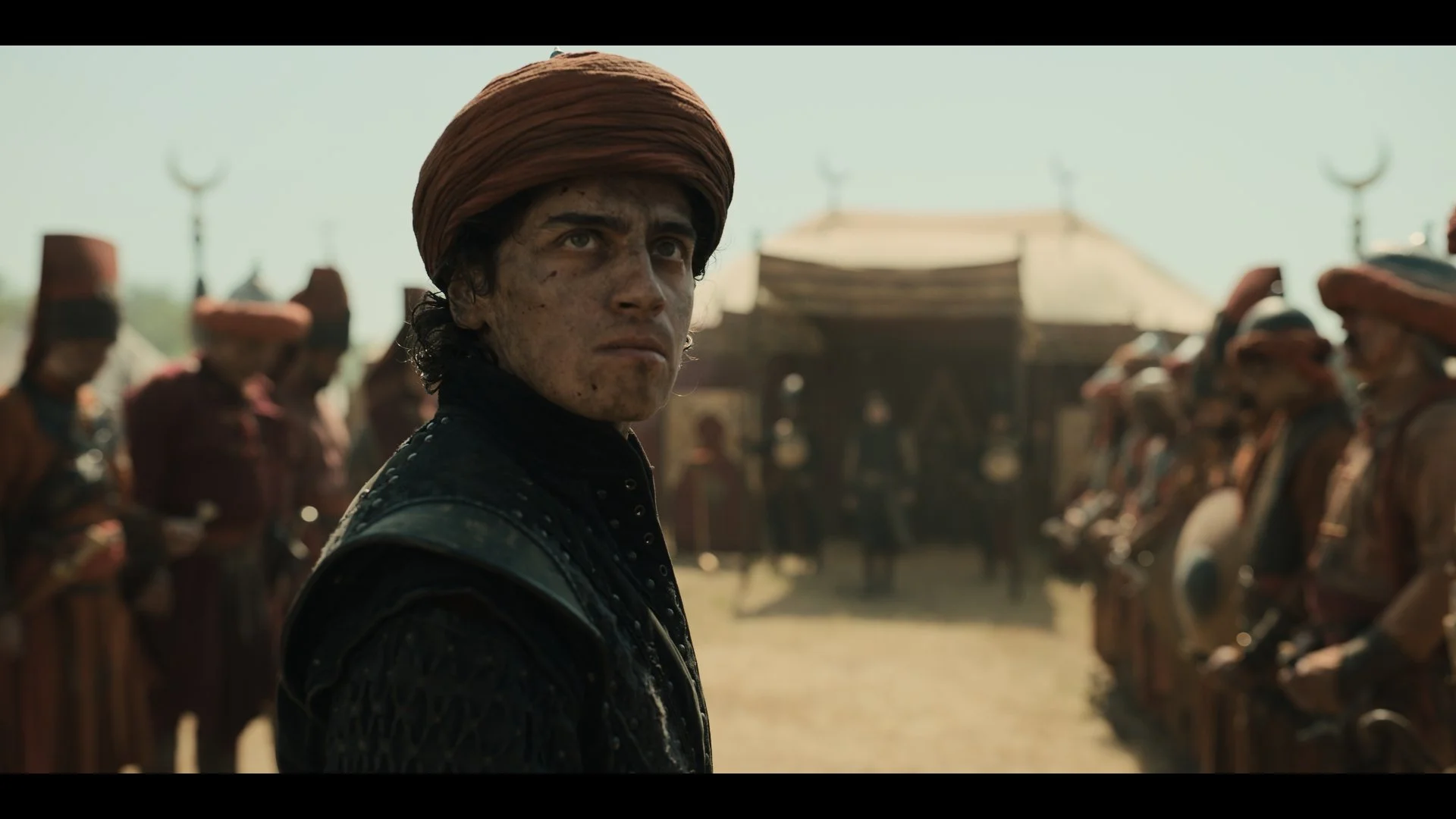Benjamin Dino as Vladut in a sunlit military camp. A still from Rise of the Raven. Cinematography by Daniel Garas.