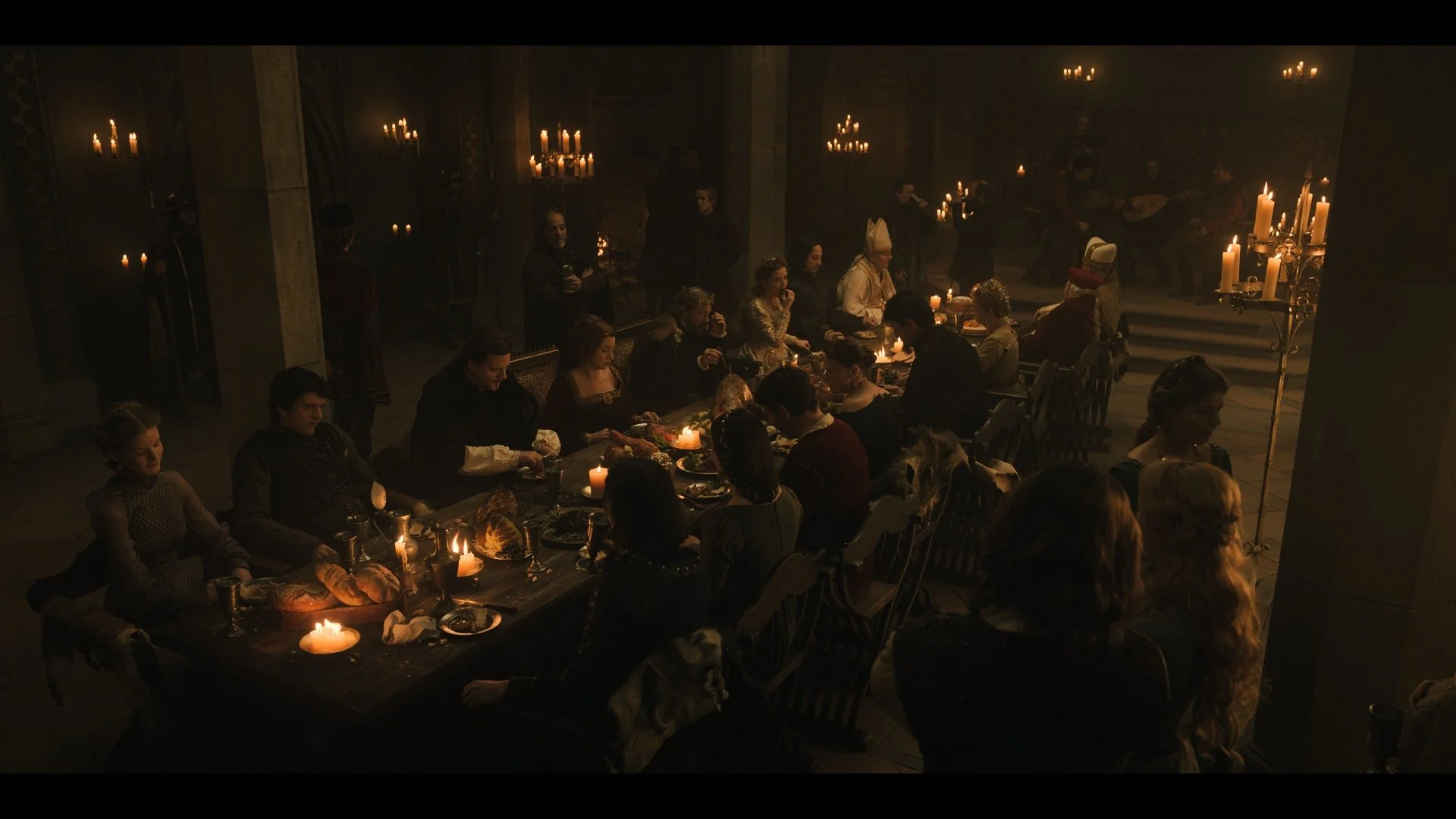 A candlelit banquet inside Buda Castle, with guests gathered around long tables. A still from Rise of the Raven. Cinematography by Daniel Garas.