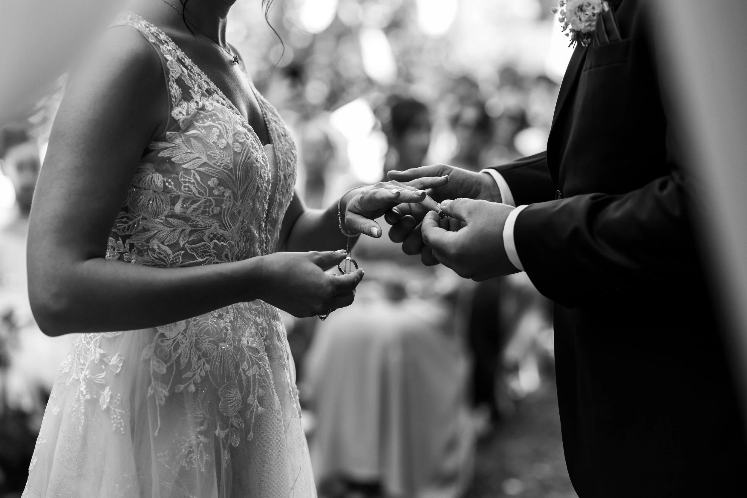 Un couple échange des anneaux lors de leur mariage, la scène en noir et blanc
