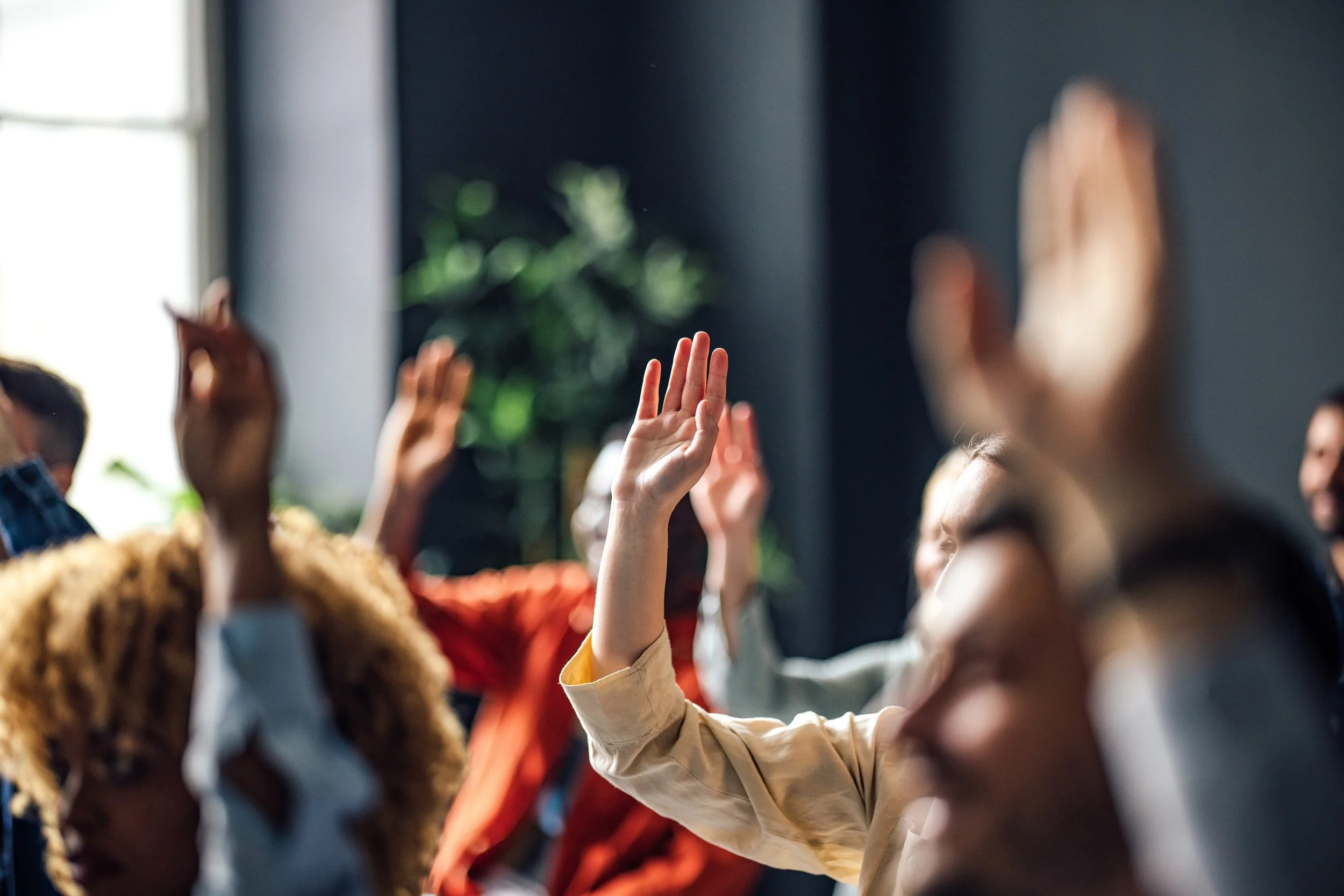 People in a room giving high fives during a meeting or workshop.