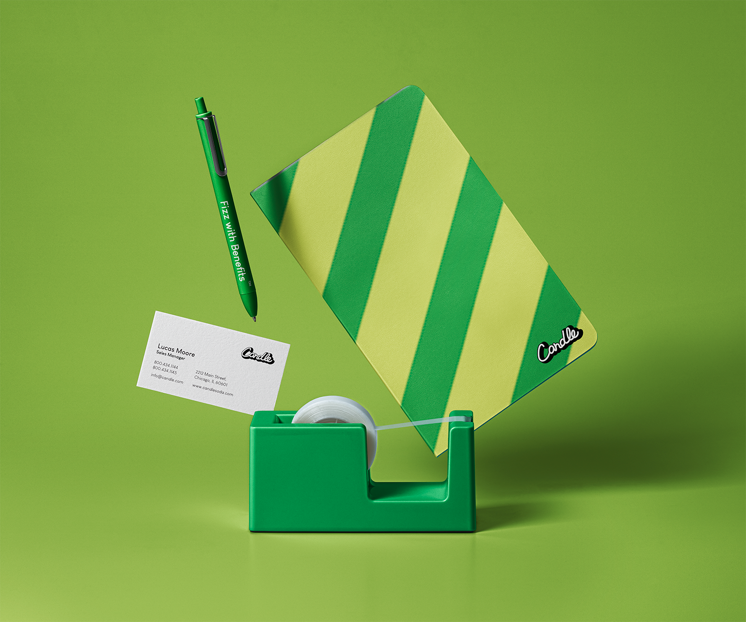 Candle desk stationery mockup with folder, pen, business card and tape dispenser on green
