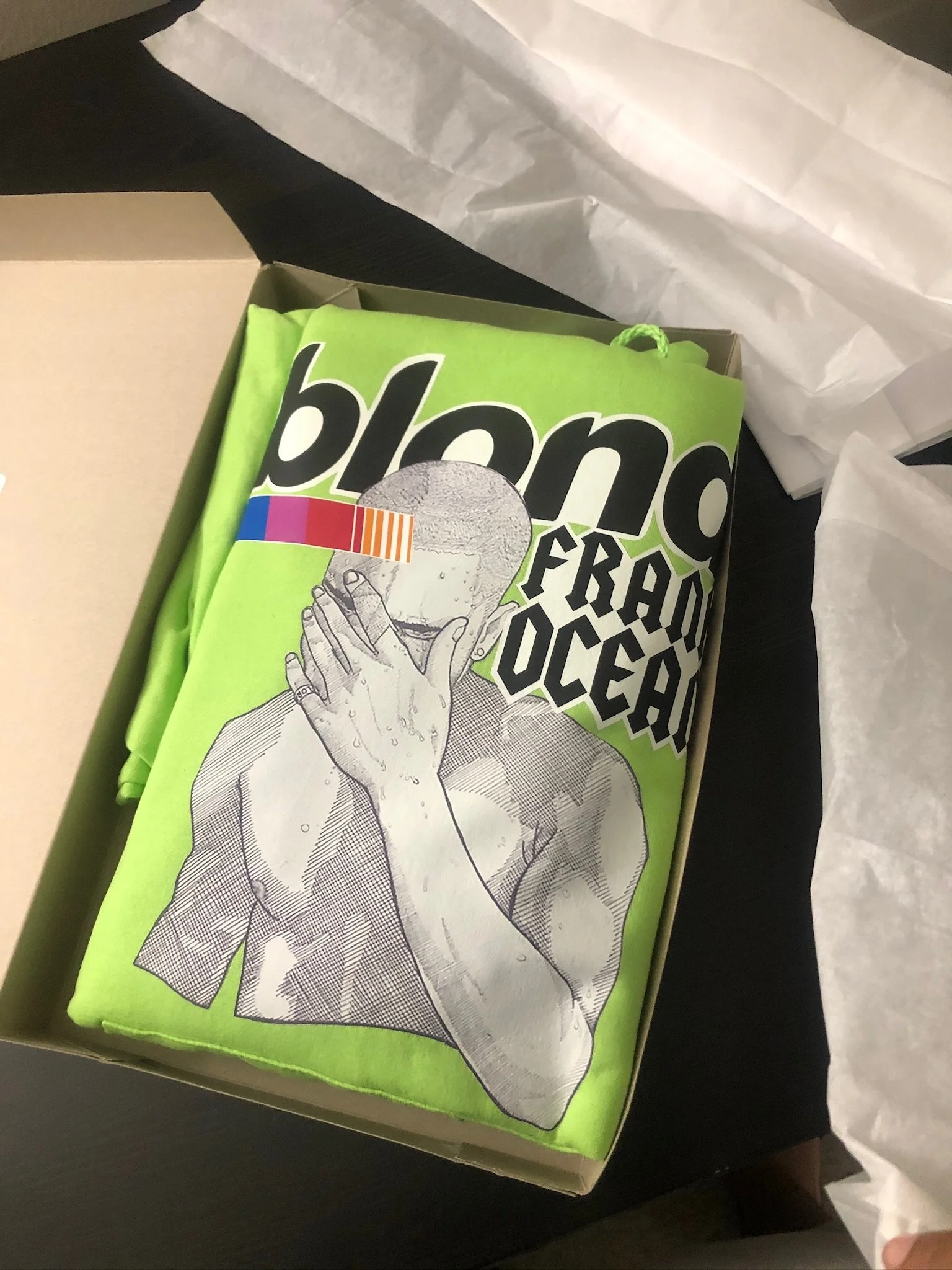 Lime green tee with a Frank Ocean Blond graphic in a box