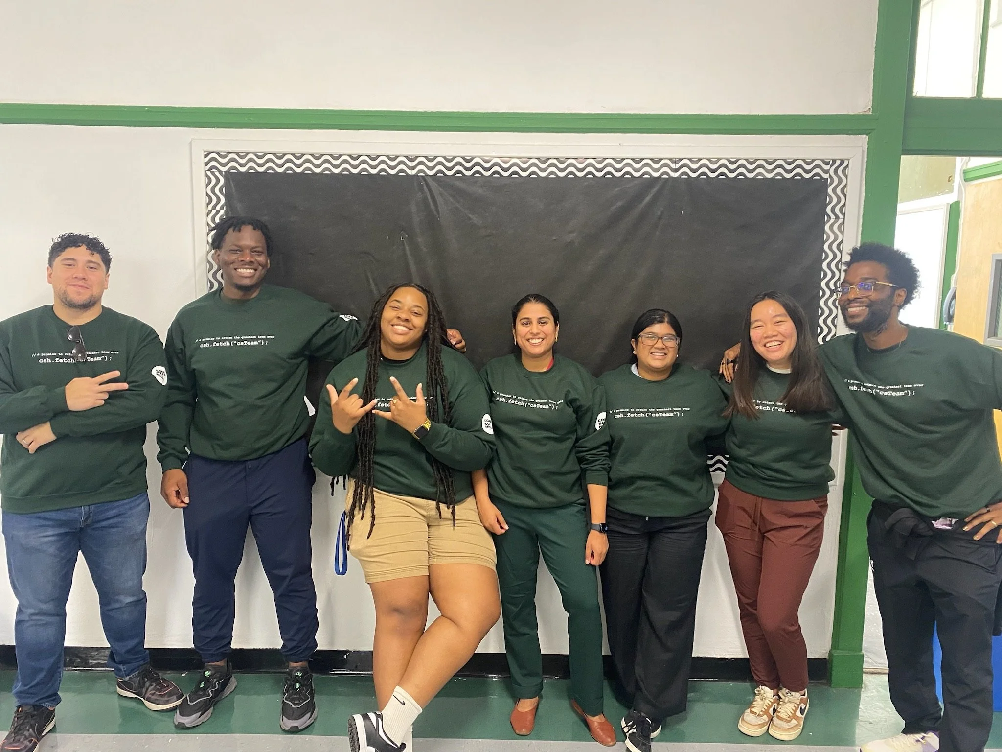 Group of school staff wearing matching custom green shirts