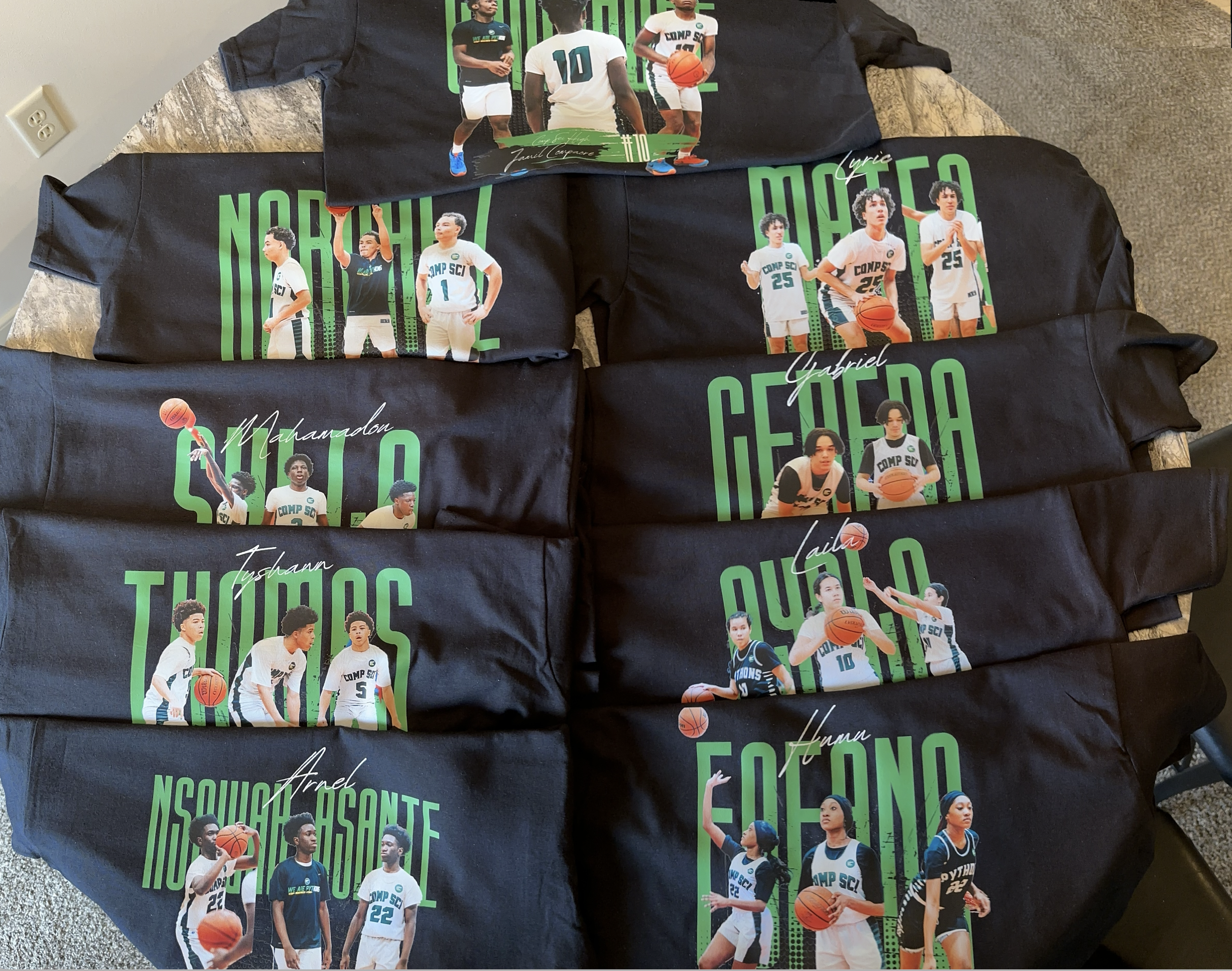 Stack of black tees printed with green senior basketball player photos and names