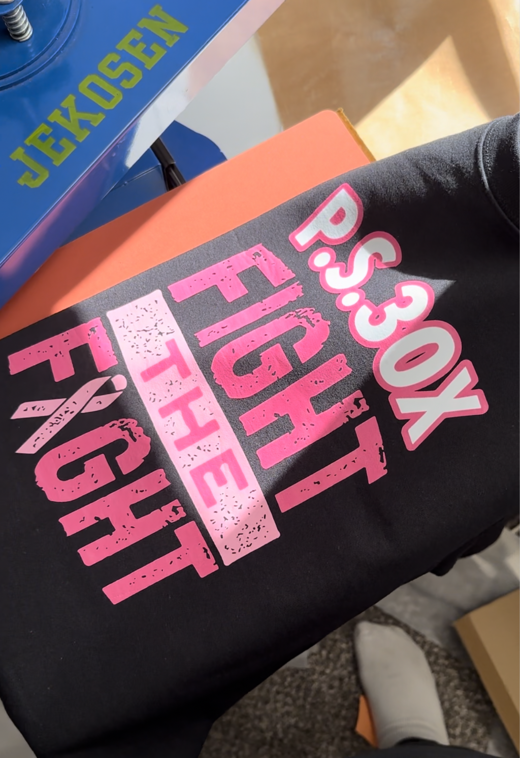 Black tee with a pink "PS 30X Fight the Fight" print