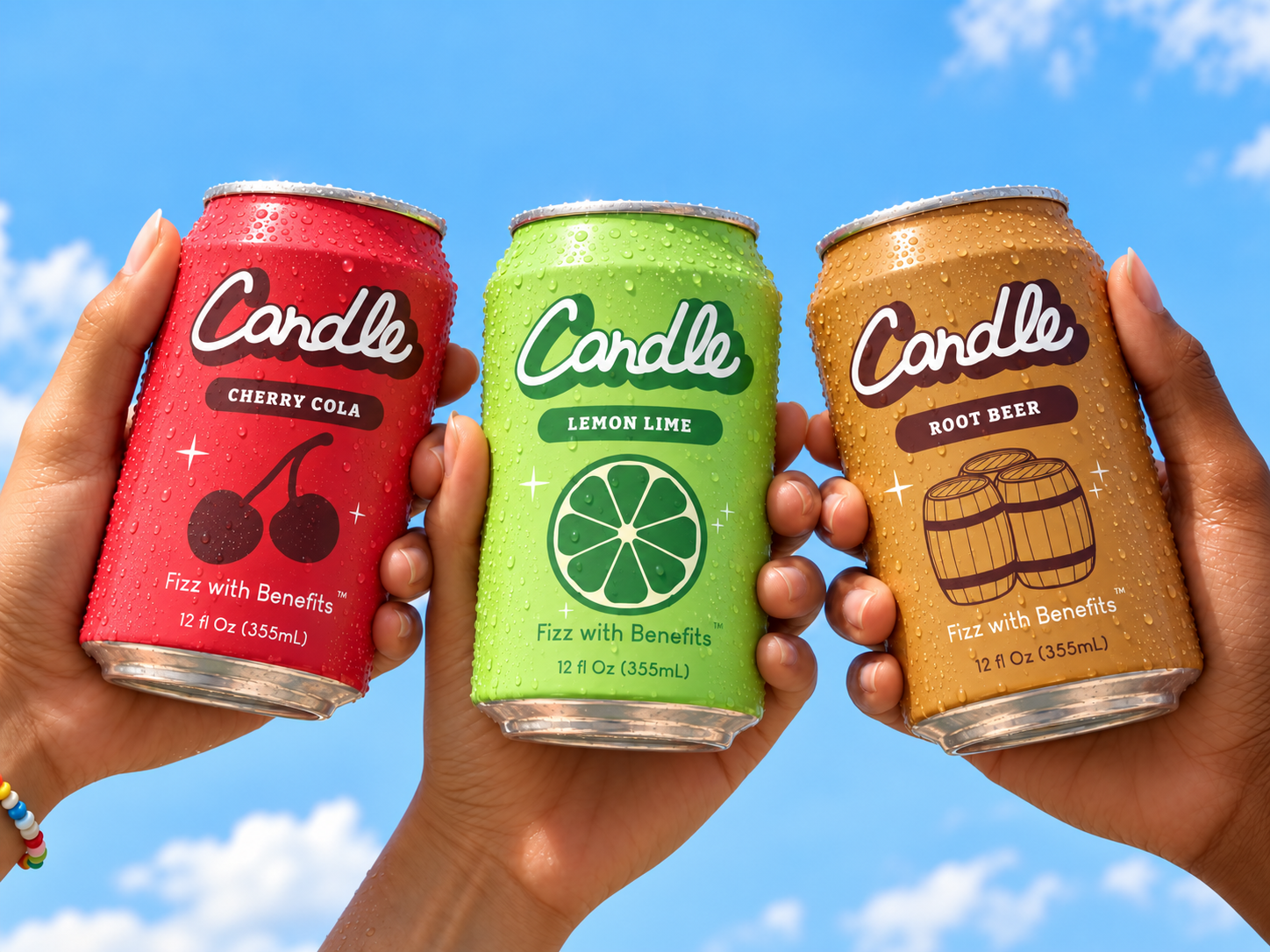 Three hands holding Candle soda cans in cherry cola, lemon lime and root beer against a blue sky