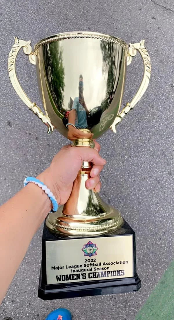 Hand holding a gold MLSA women's championship trophy