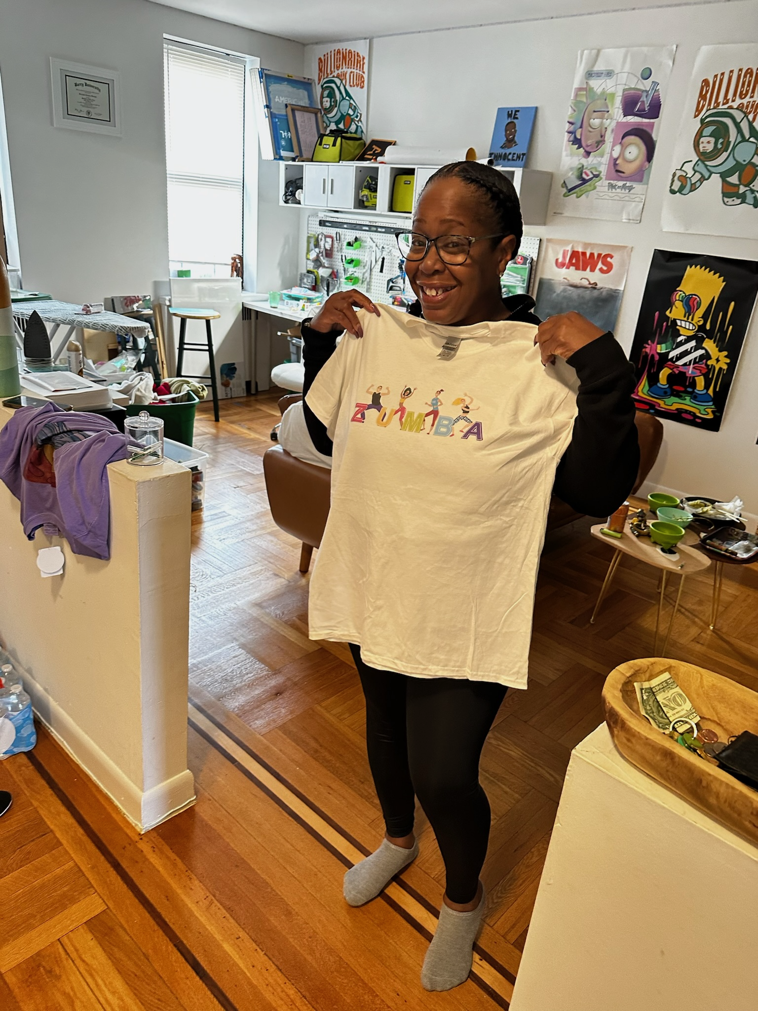 Customer smiling and holding up a custom printed tee at home