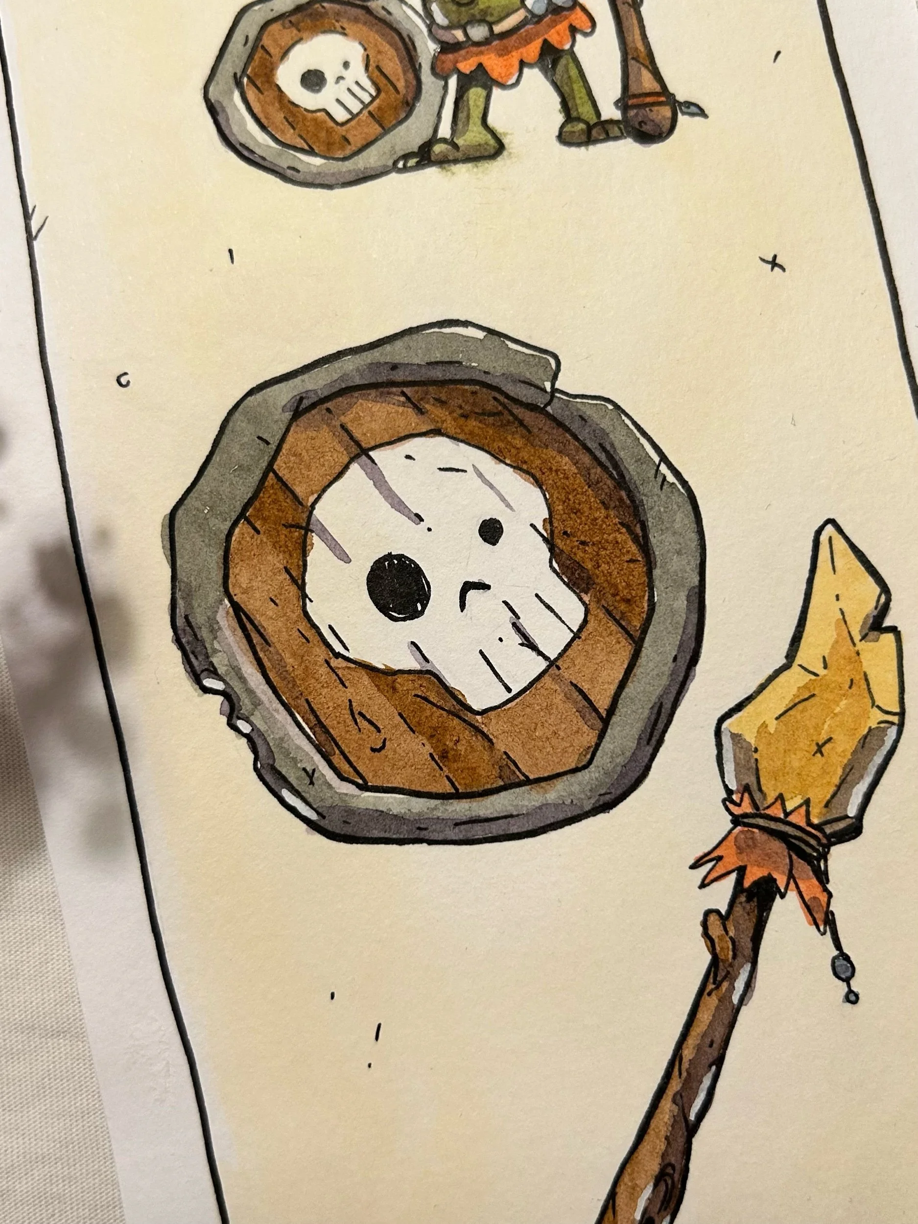 Round wooden shield with a white skull, close-up of a goblin illustration in ink and watercolor.