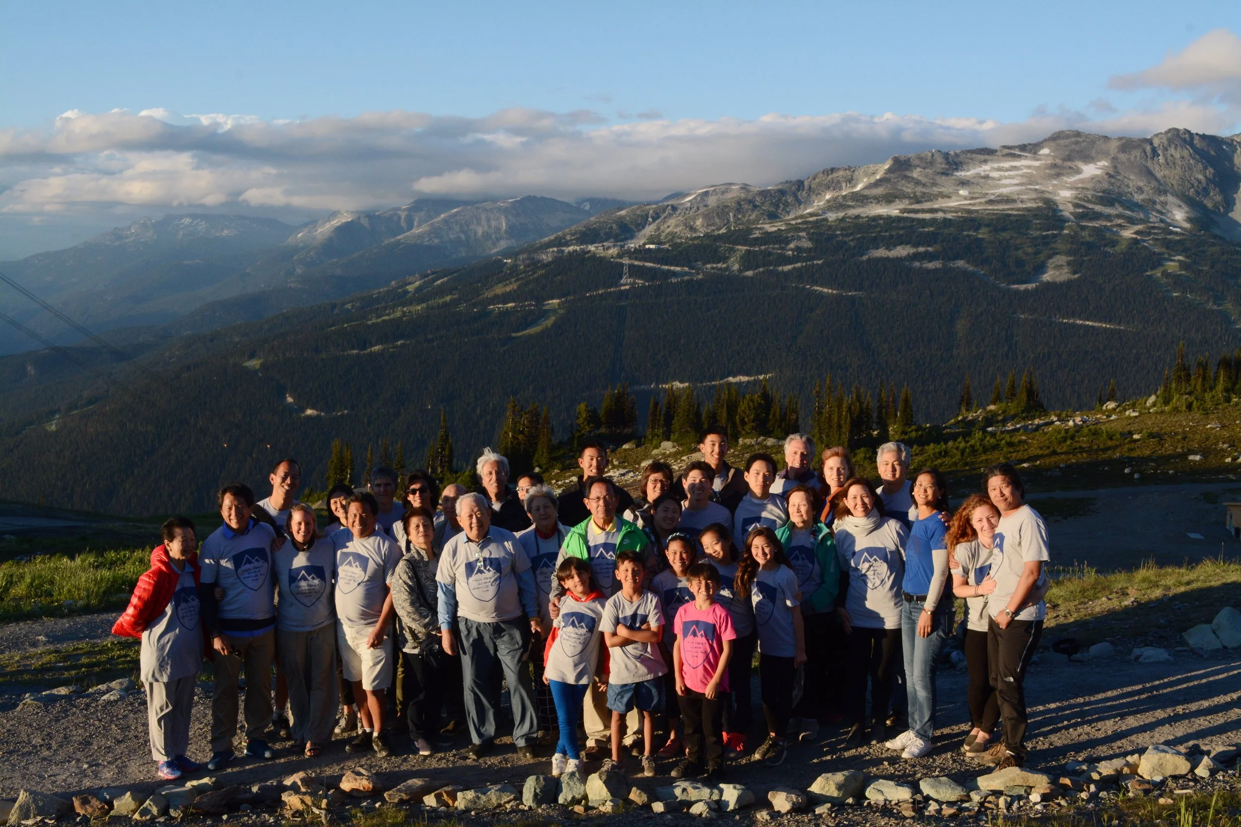 Family reunion on a glacier at Whistler. Mountain range and clouds in the background