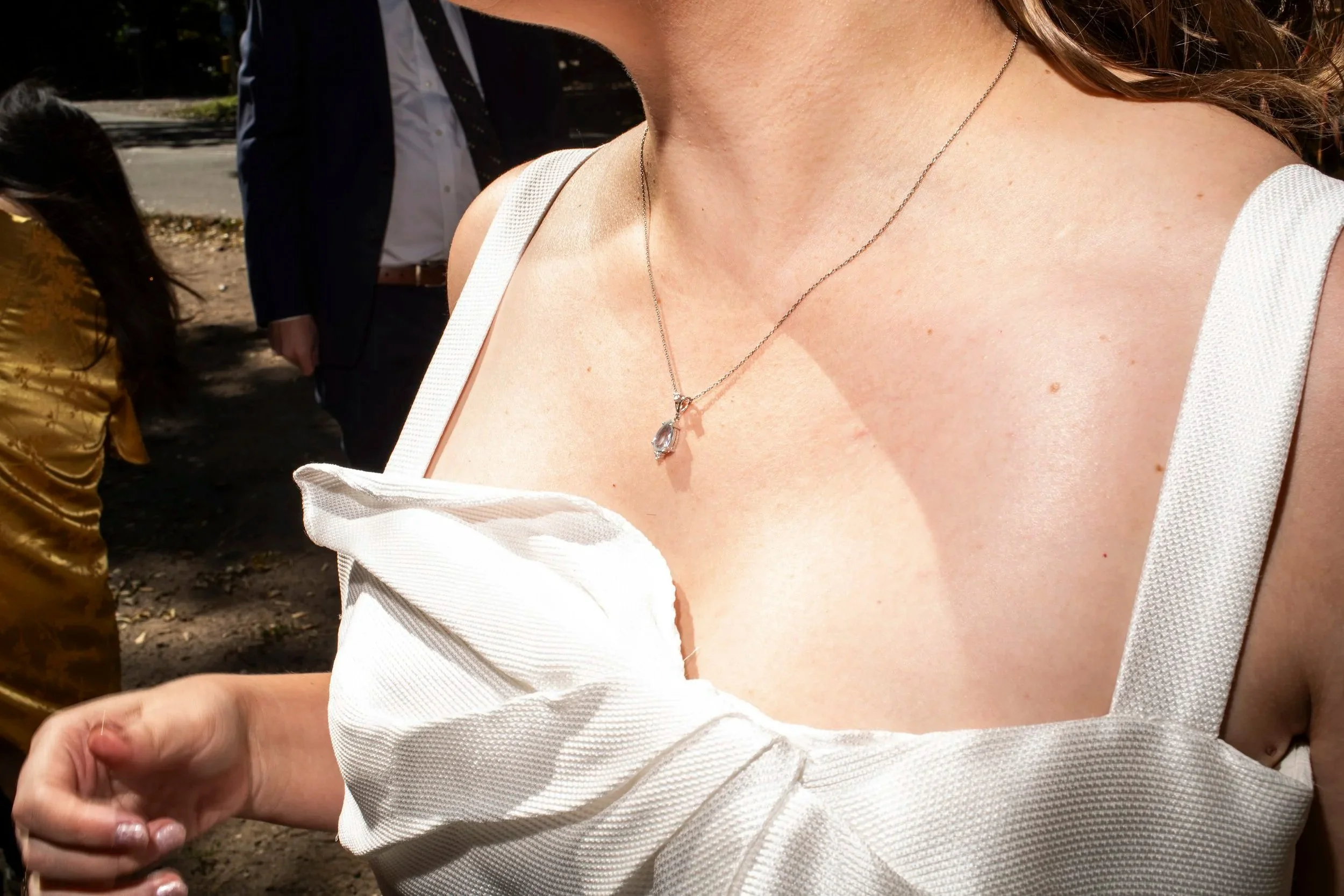 Woman wearing a necklace with a tiny aquamarine pendant shot in Brooklyn
