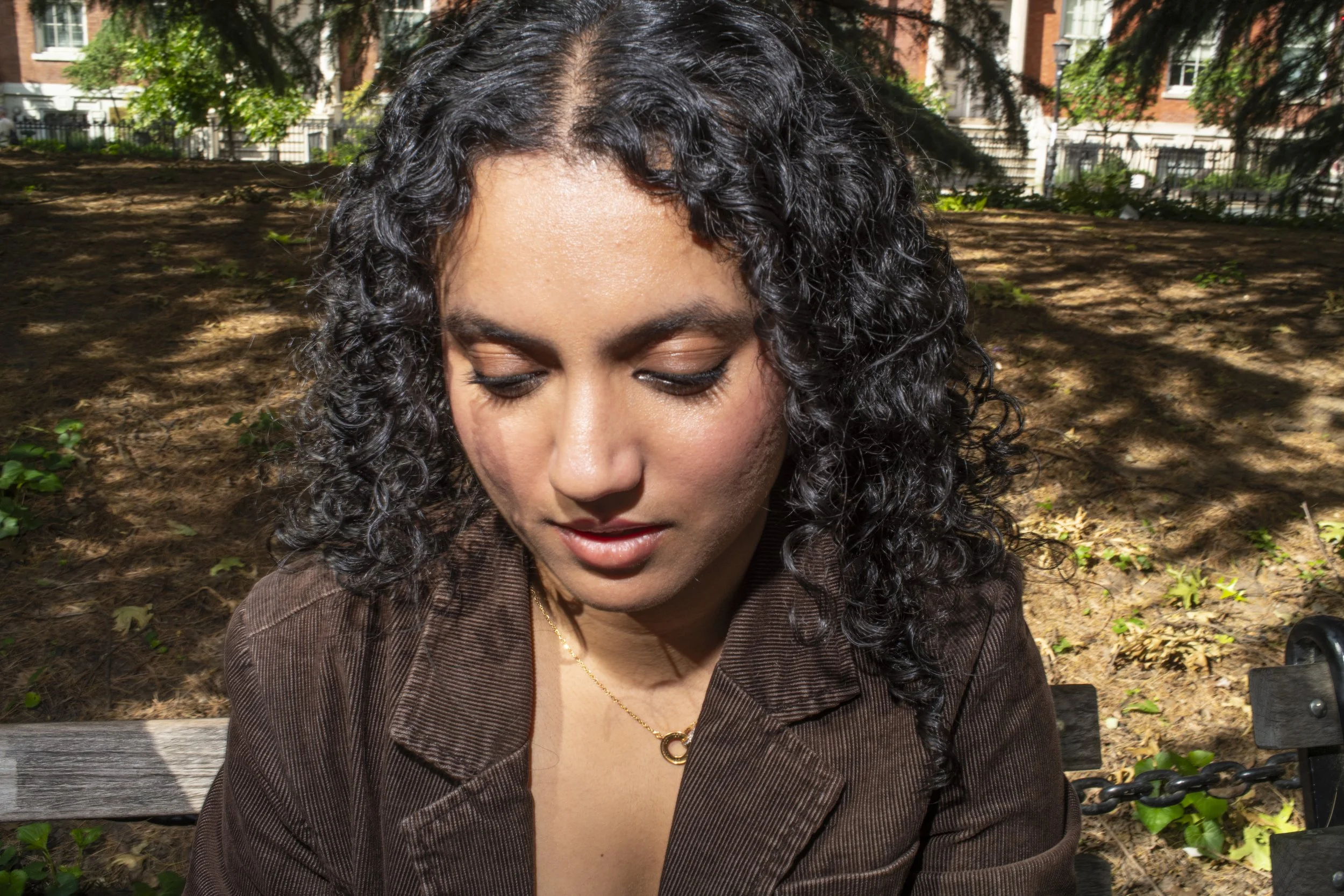 Woman wearing a tiny gold necklace with a pendant in New York City