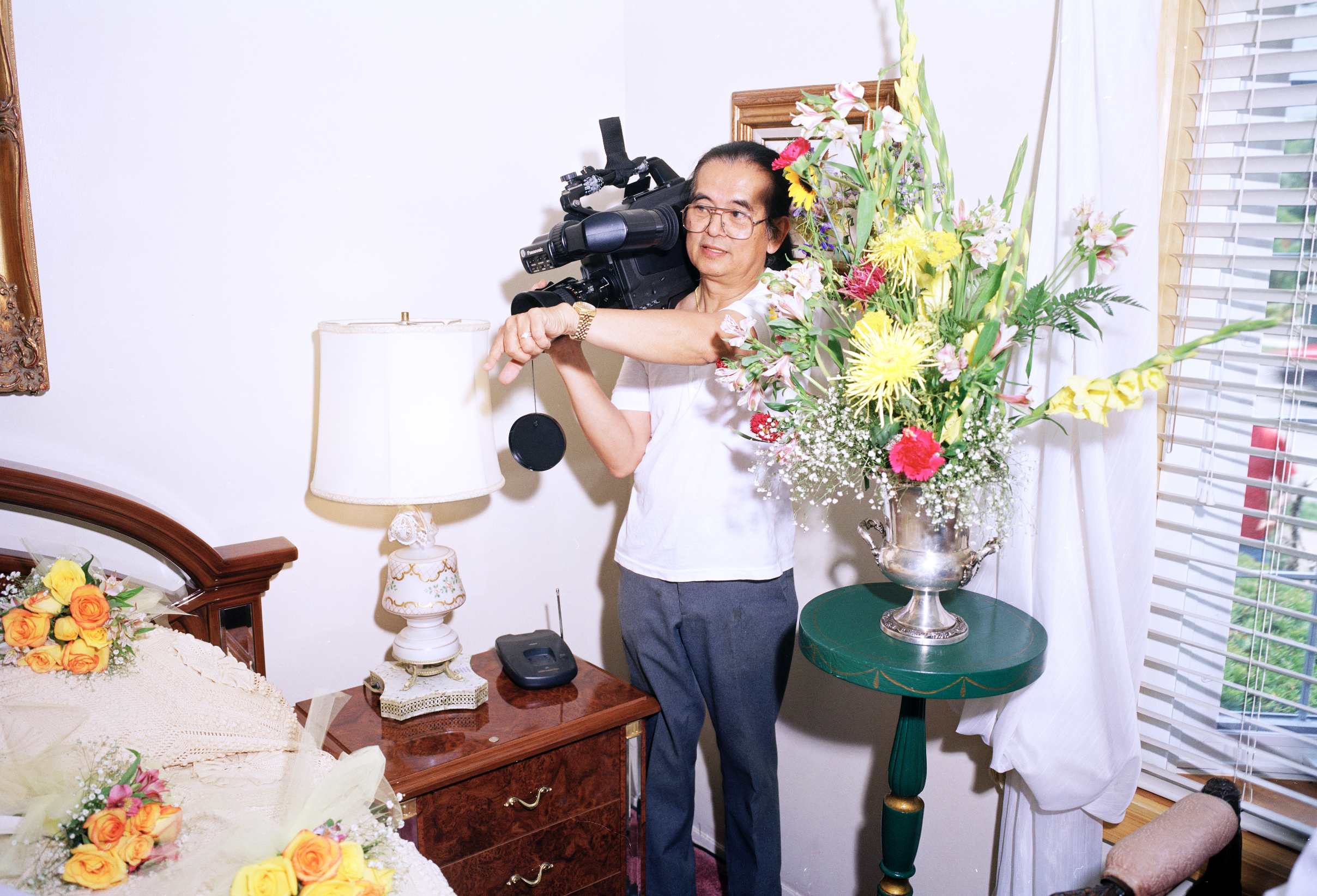 Man filming with a large video camera in a bridal suite