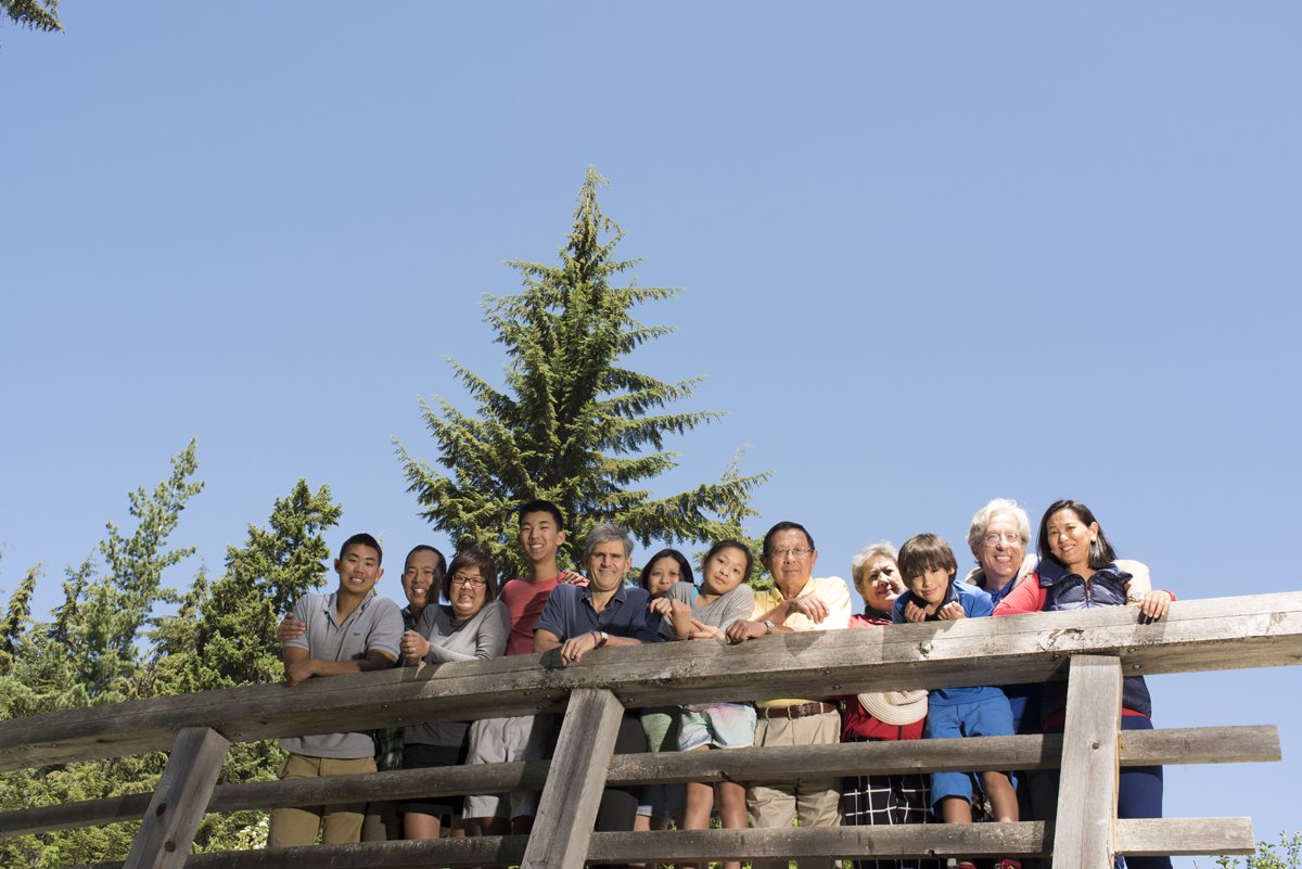 Whole family looking down from a bridge in Whistler, photographed from below