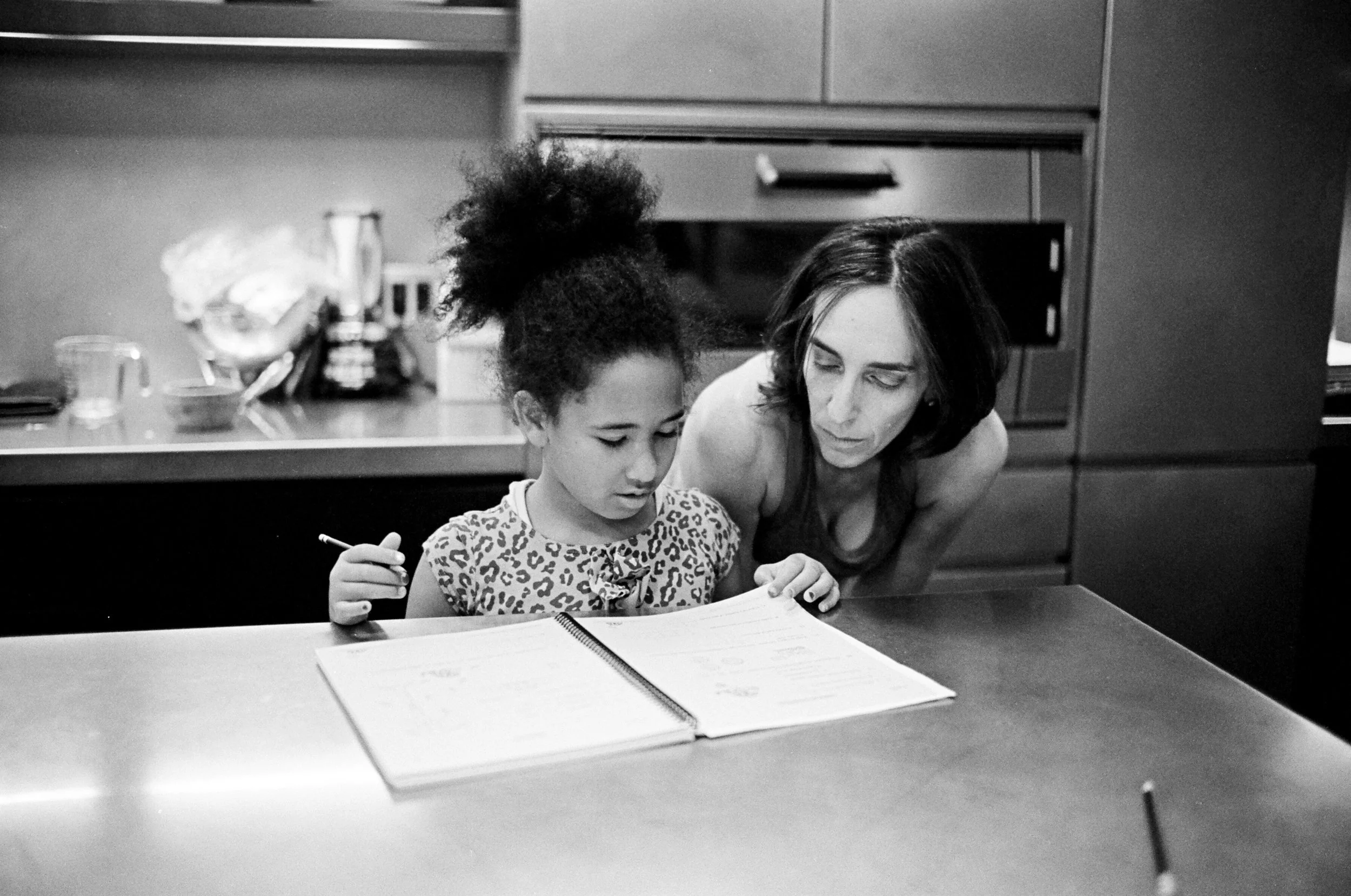 Candid lifestyle family photography of mother and daughter inside a  Manhattan townhouse kitchen. Shot with real black and white film.