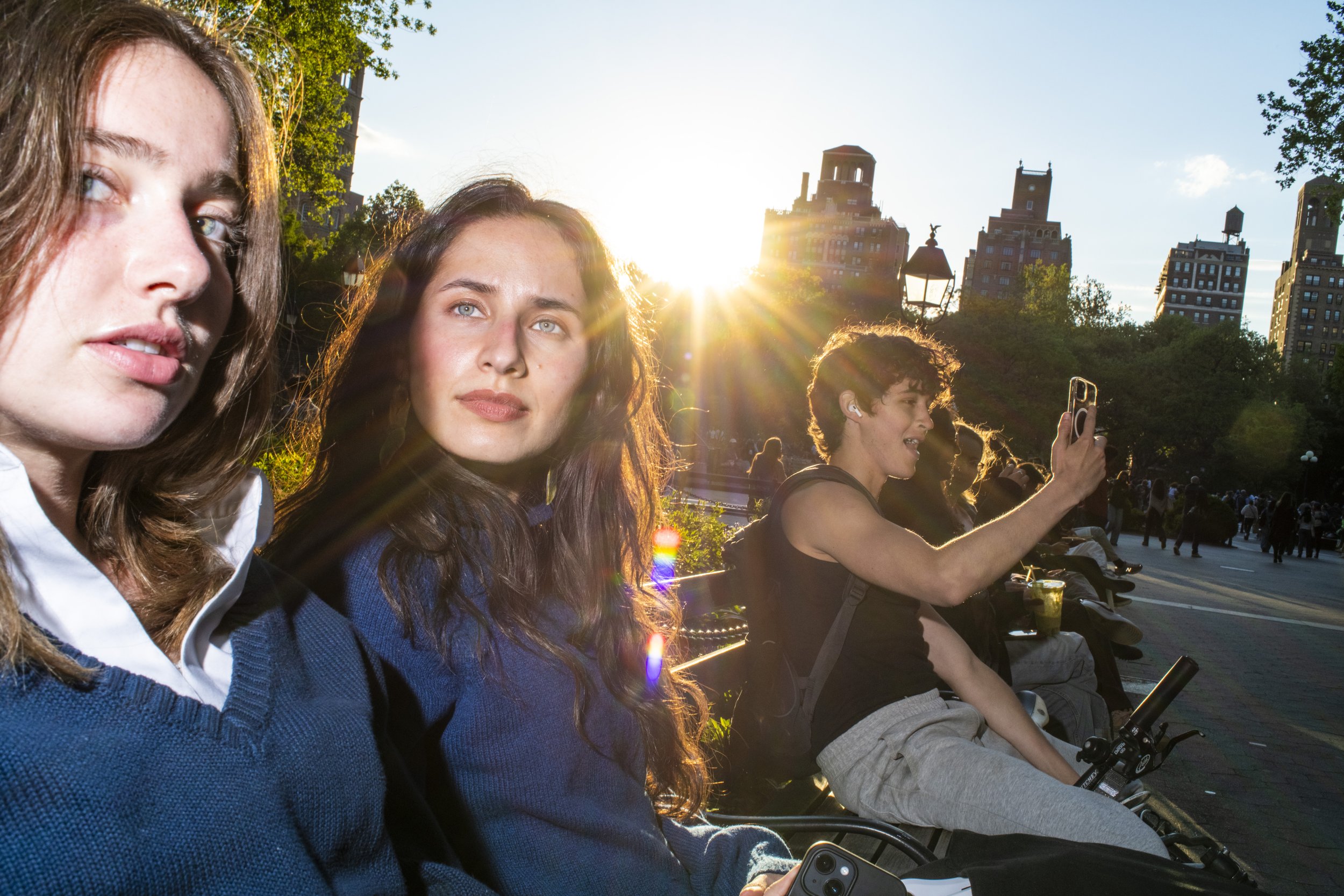 Color street photograph of a pair of young women on a park bench