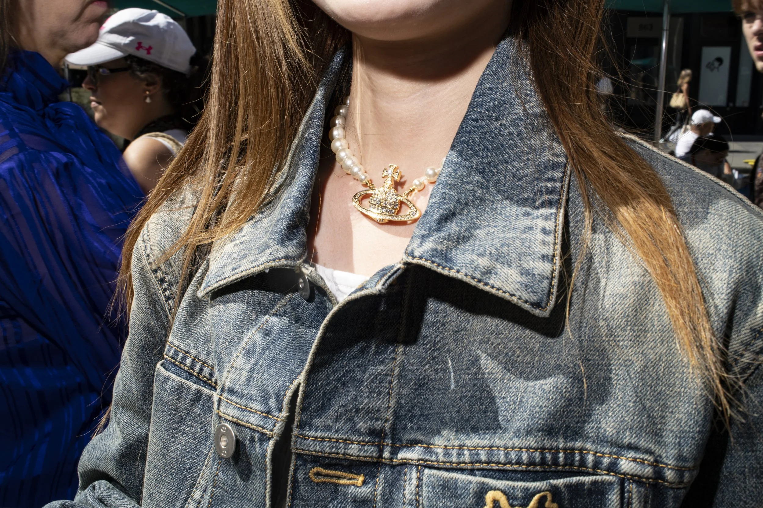Woman wearing a pearl choker necklace with a gold pendant in New York City