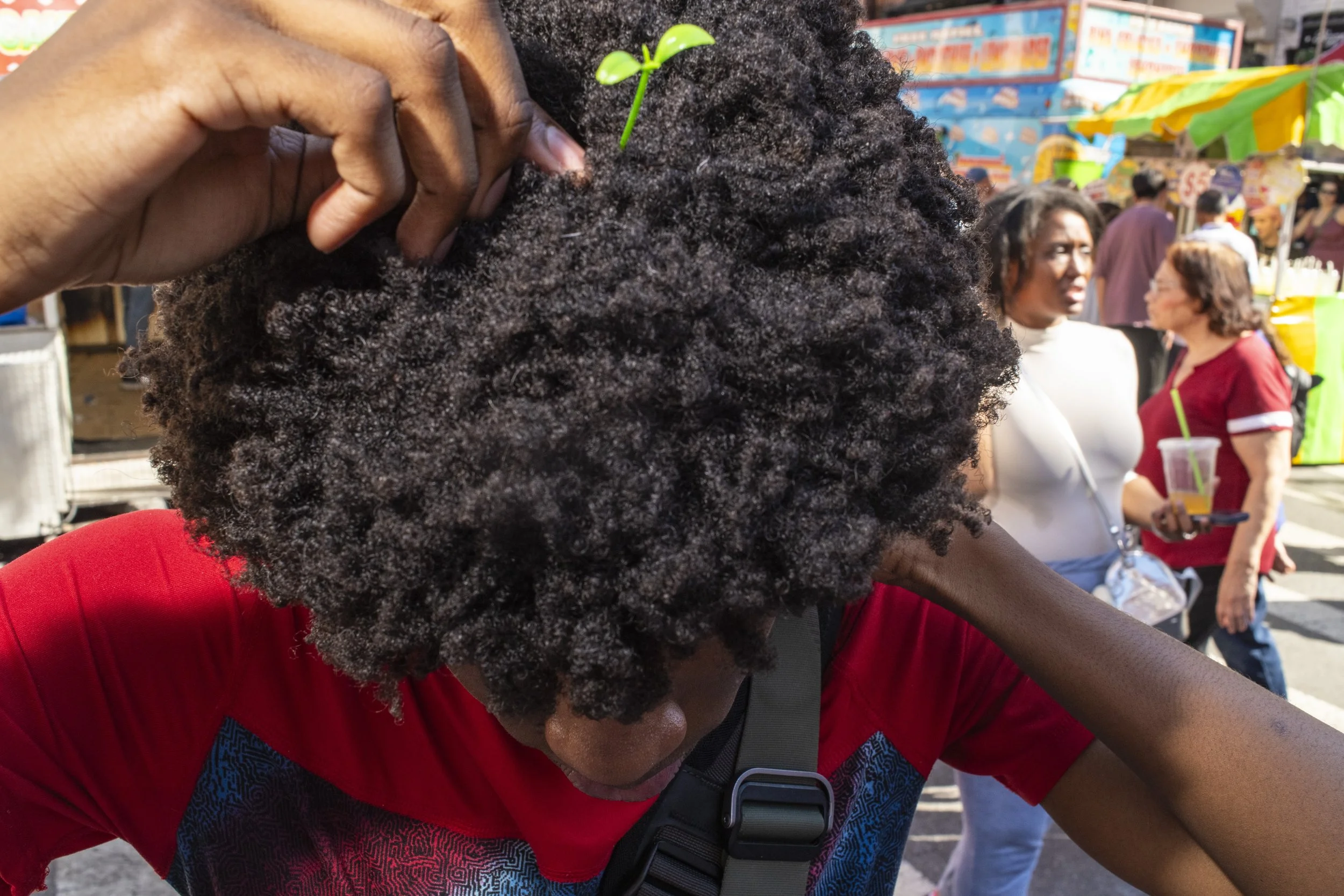 A young man adds a sprout charm into his afro
