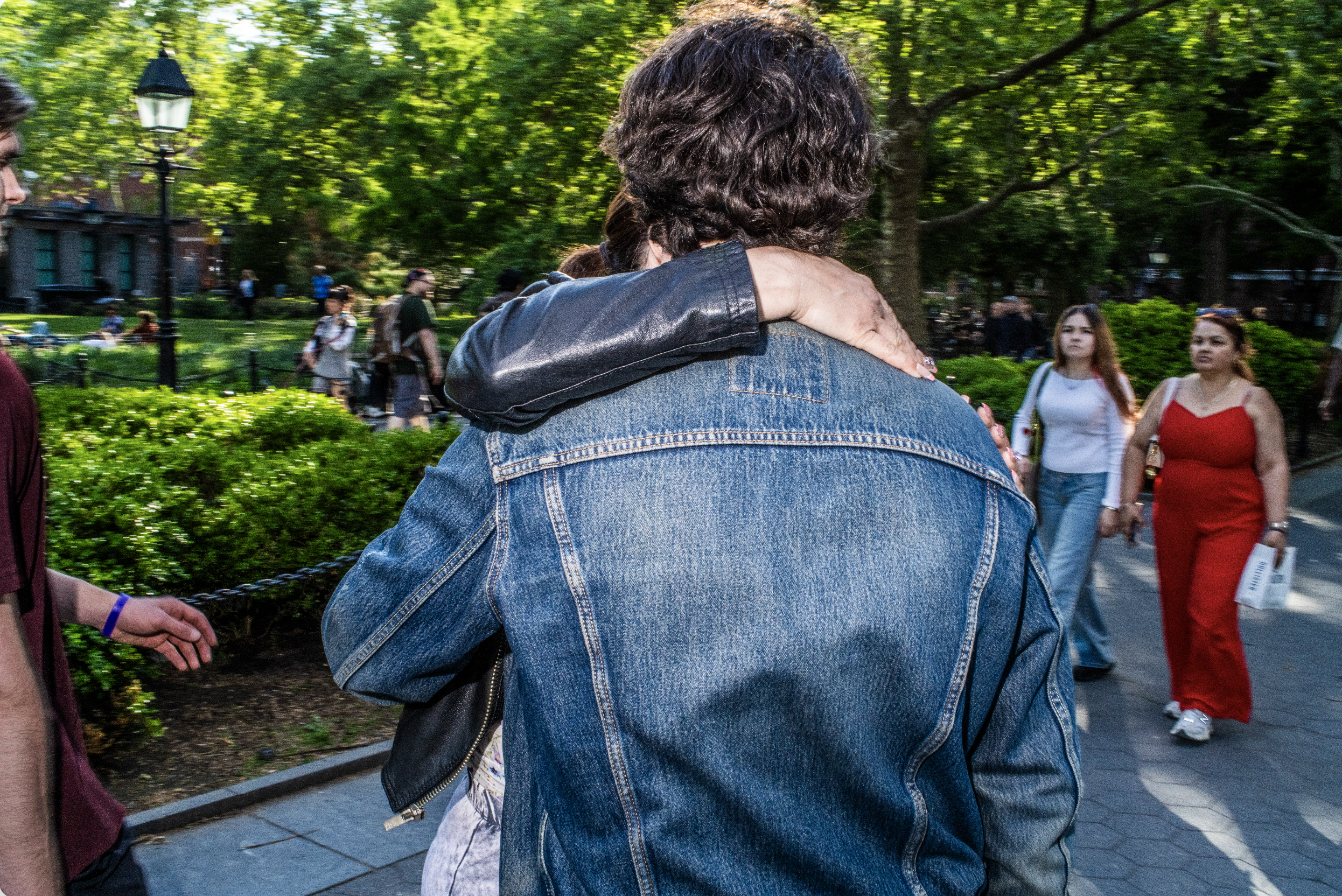 Color street photograph of a couple embracing in a park
