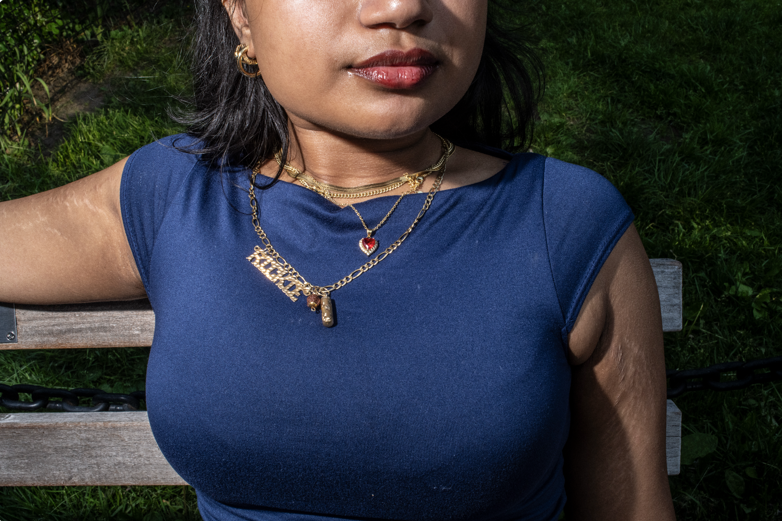Portrait of a woman wearing multiple personal charms and necklaces over a blue tshirt