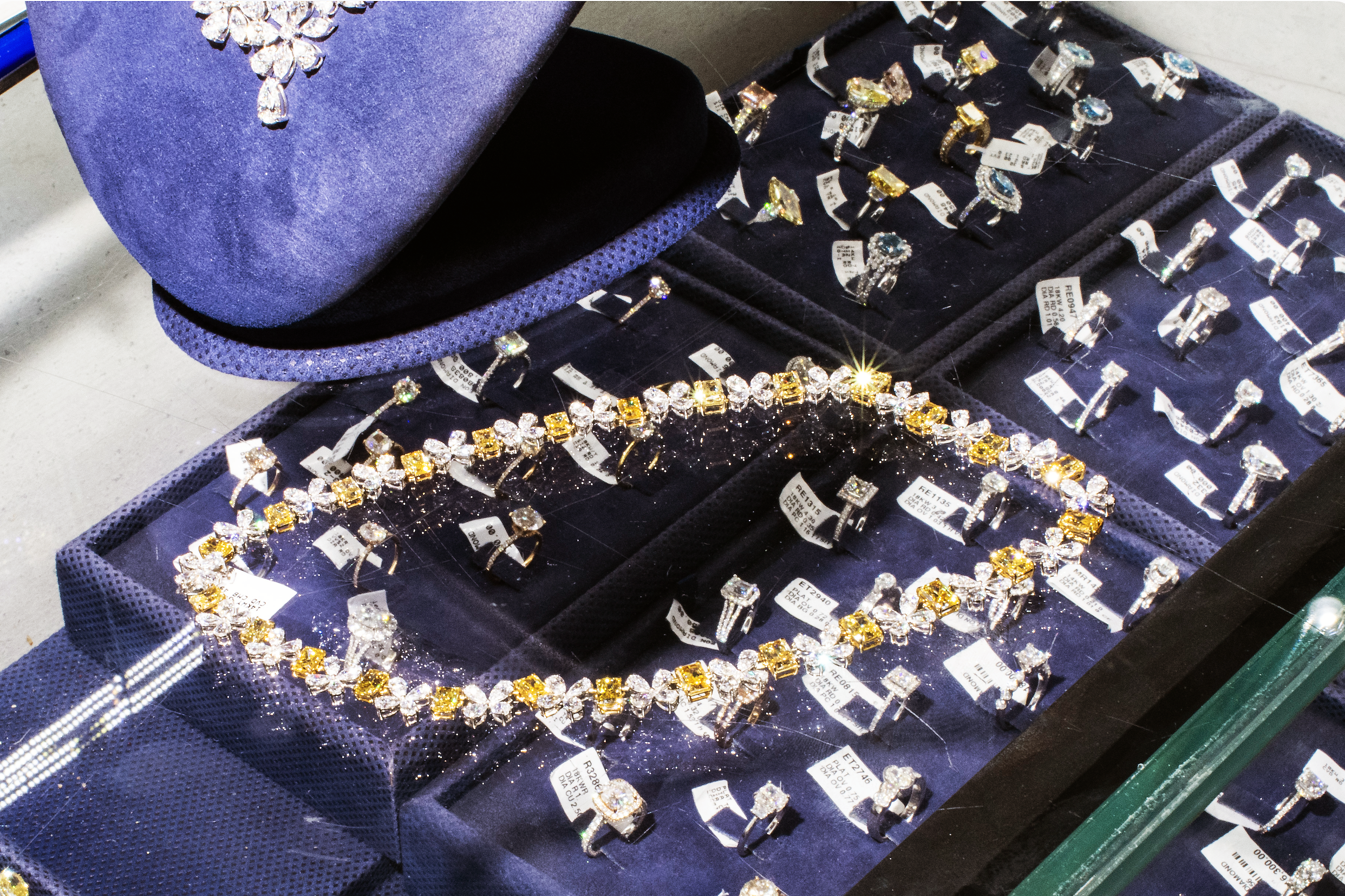 a yellow and white diamond choker on the glass case of a jewelry shop.