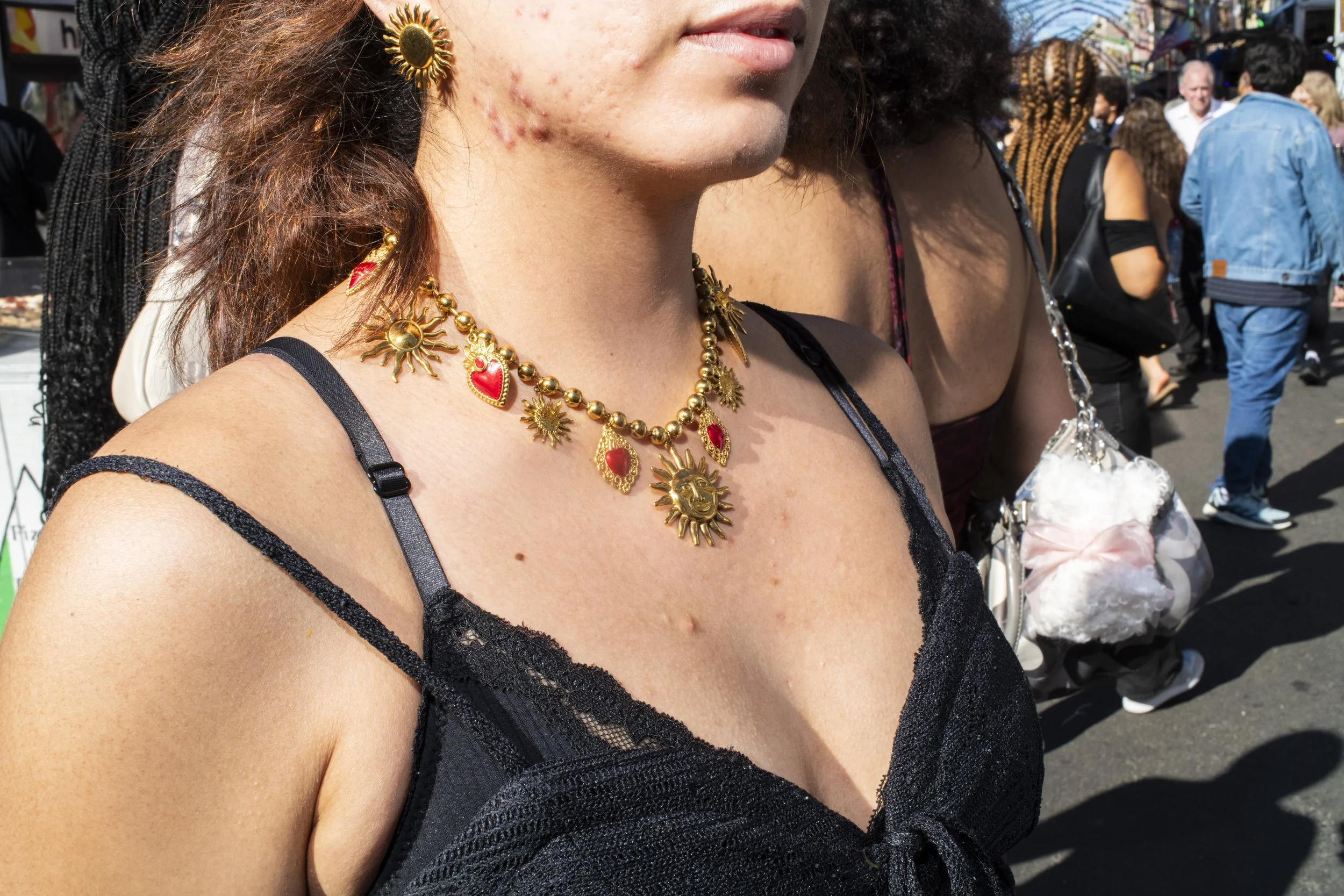 Portrait of a woman wearing a large, costume necklace in gold