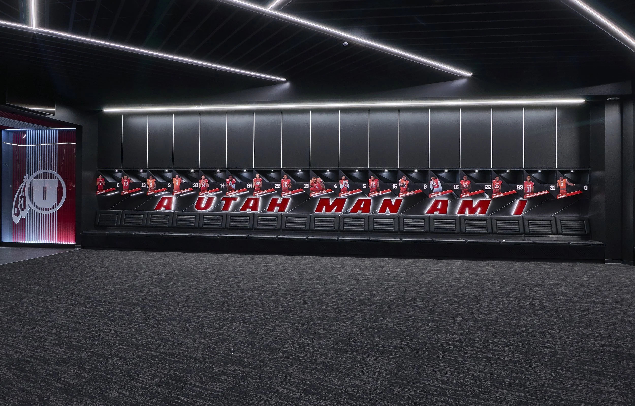 Locker room with football jerseys of Utah Utes hanging above bench and the phrase 'UTAH MAN AM I' displayed on the wall.
