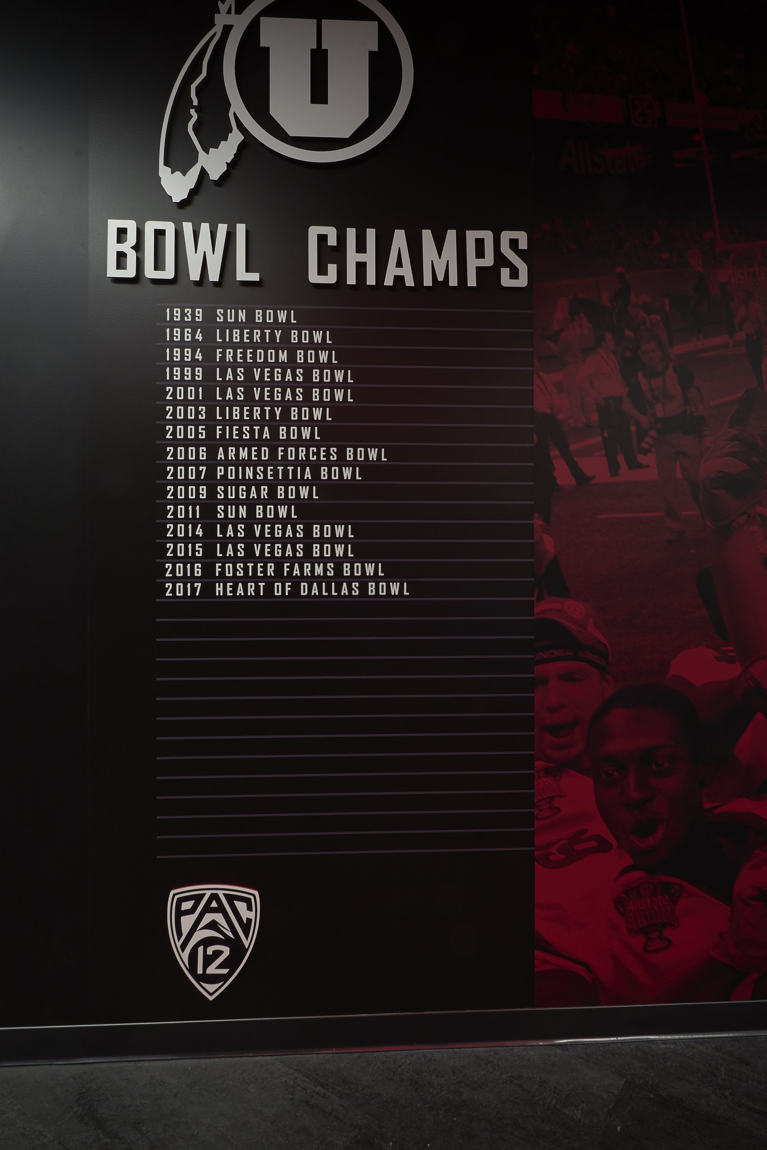 A wall display listing University of Utah's college football bowl game victories from 1939 to 2017, titled 'Bowl Champs,' with the Utah Utes logo and a background photo of celebrating players.