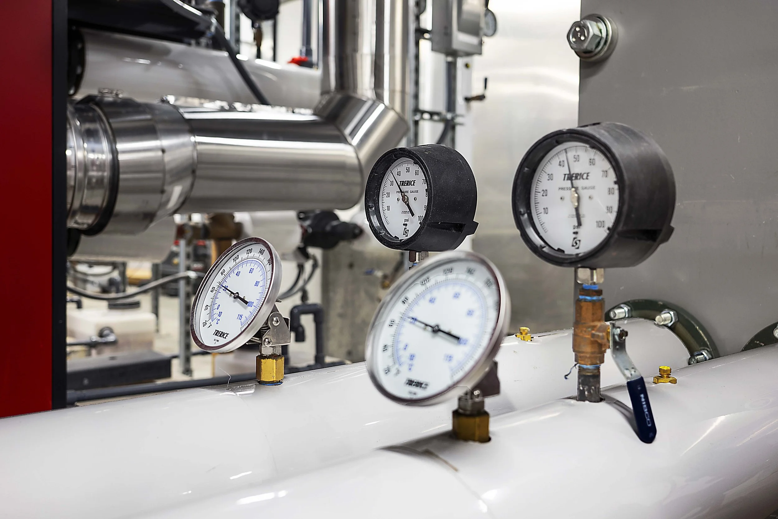 Pressure gauges attached to a pipeline in an industrial setting.