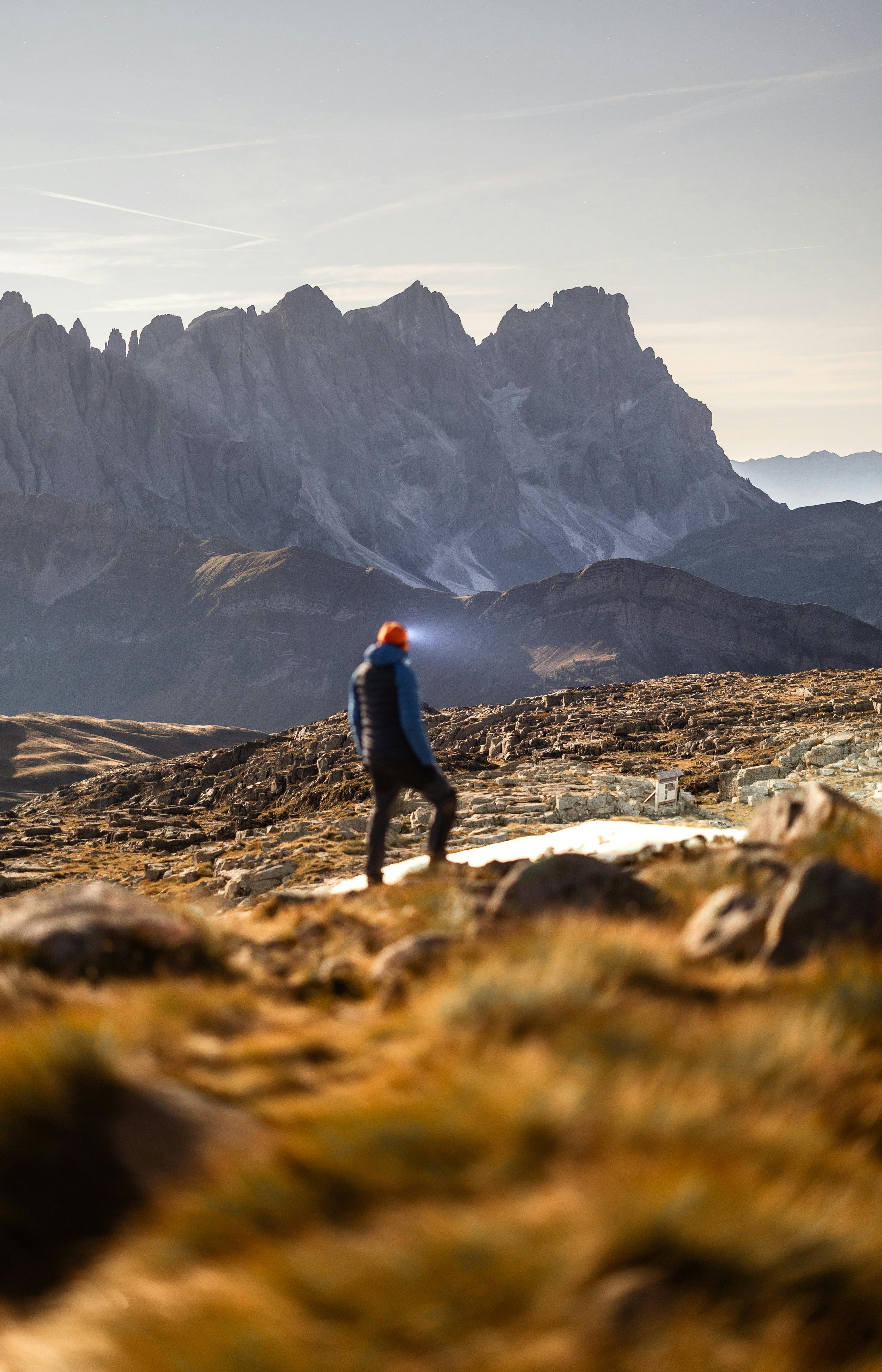 hiker in mountains looking towards higher peaks signifying overcoming challenges related to new years resolutions