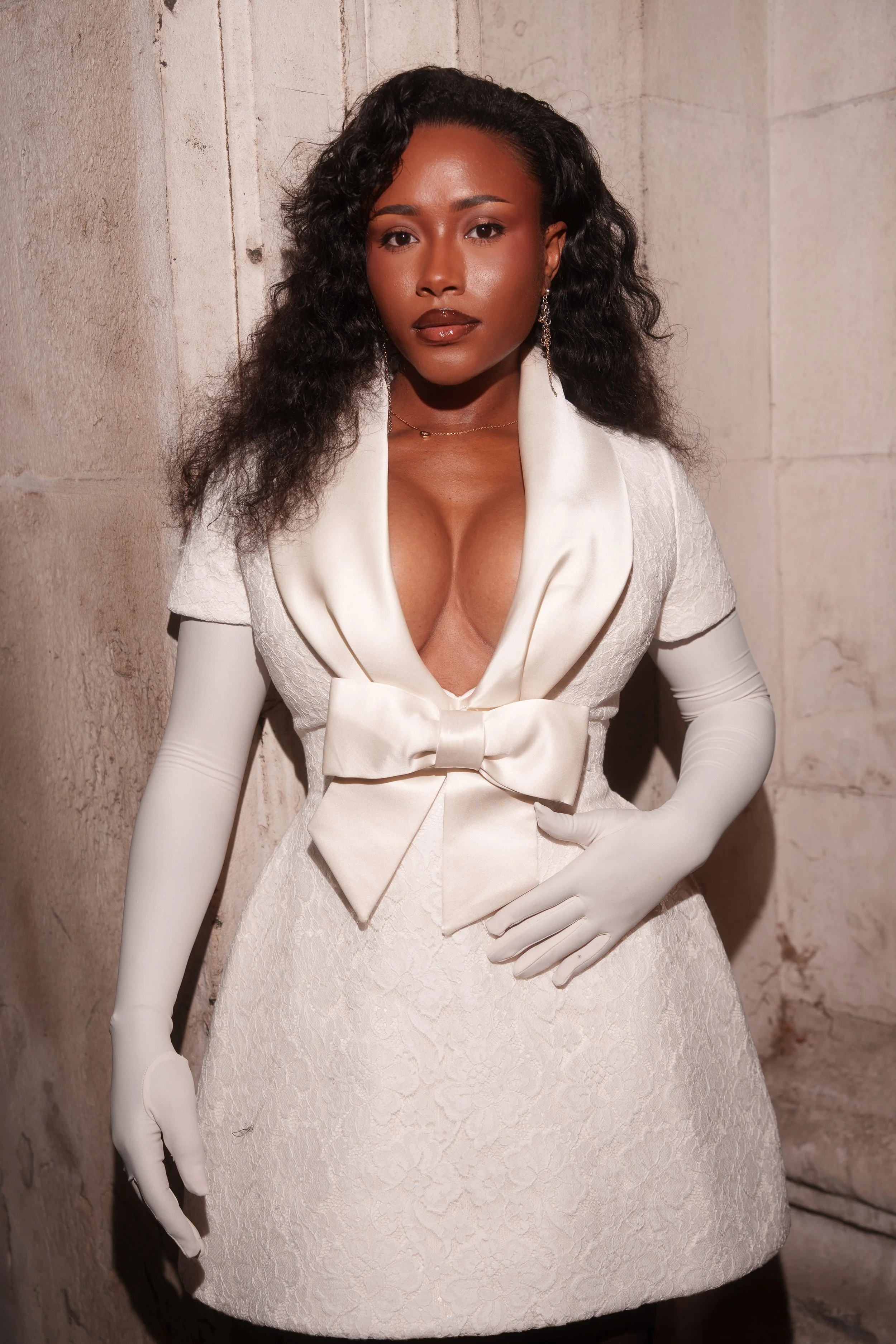 Tolami Benson, a black woman, current Bukayo Saka's fiancee wearing a white dress with a bow in the middle. Pictured prior to entering the Richard Quinn fashion show in September 2025