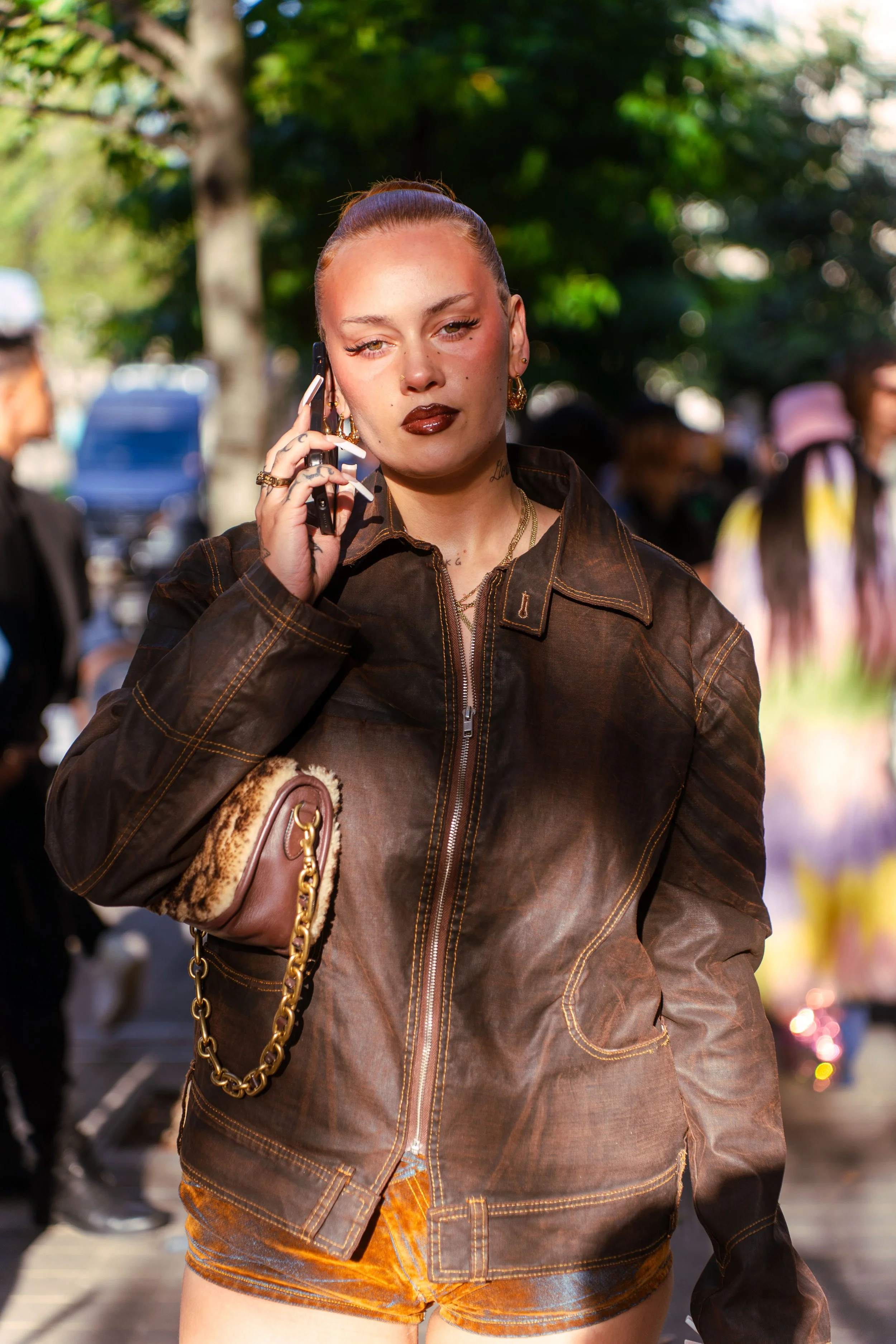 Image of a girl (Sasha Keable) who is on the phone outside of a fashion show