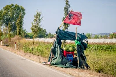 Watermelon stall by the road with Albania flag