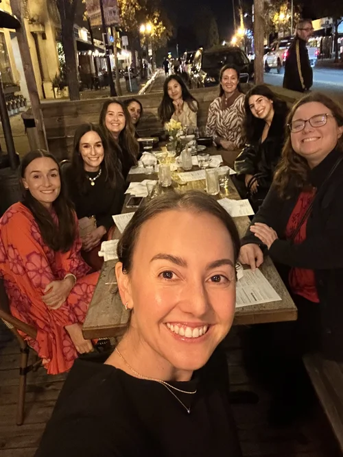 Paige hosting a dinner with a full table of women
