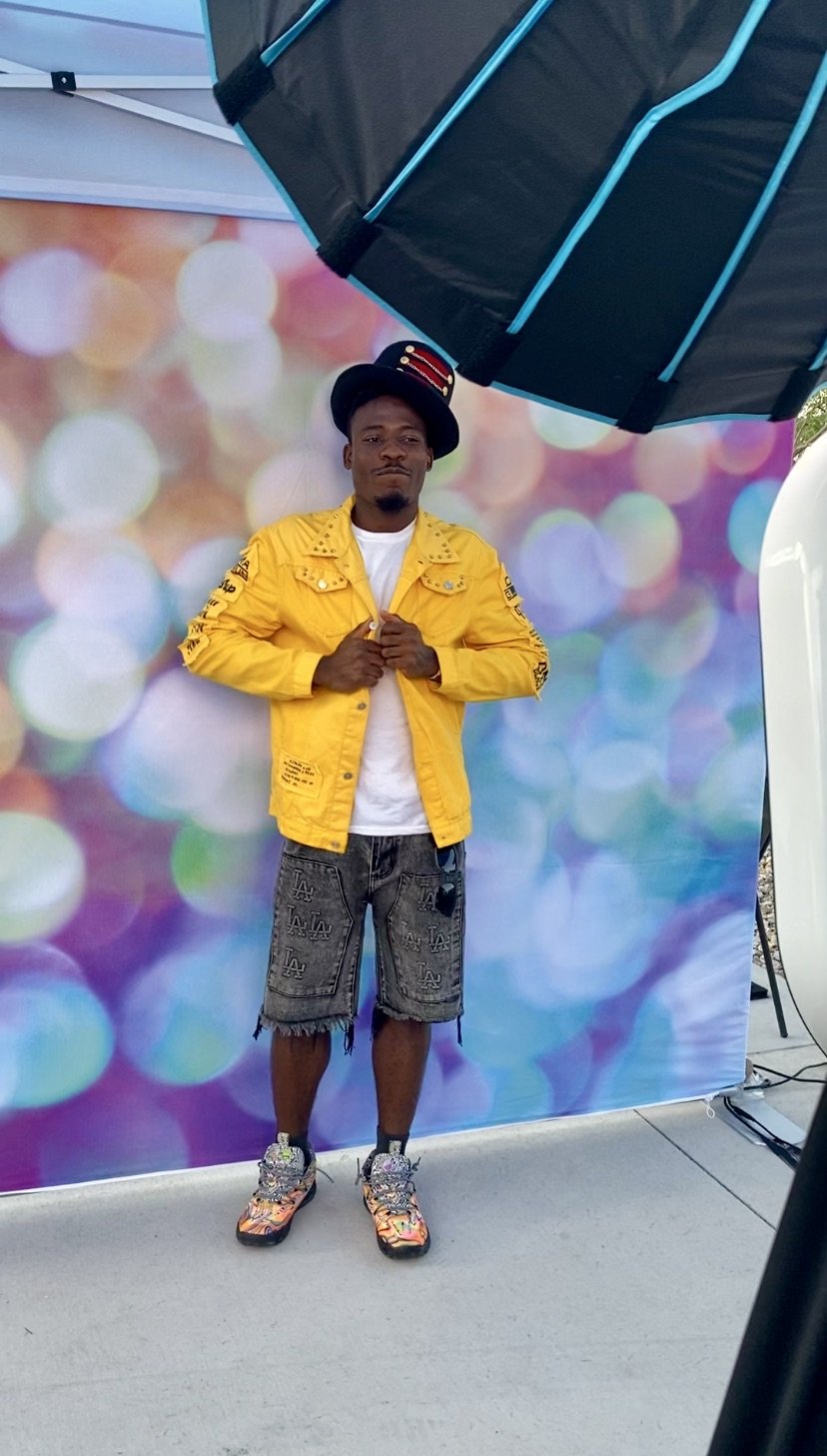 A woman smiling while posing in front of a device on a rooftop with a cityscape background.
