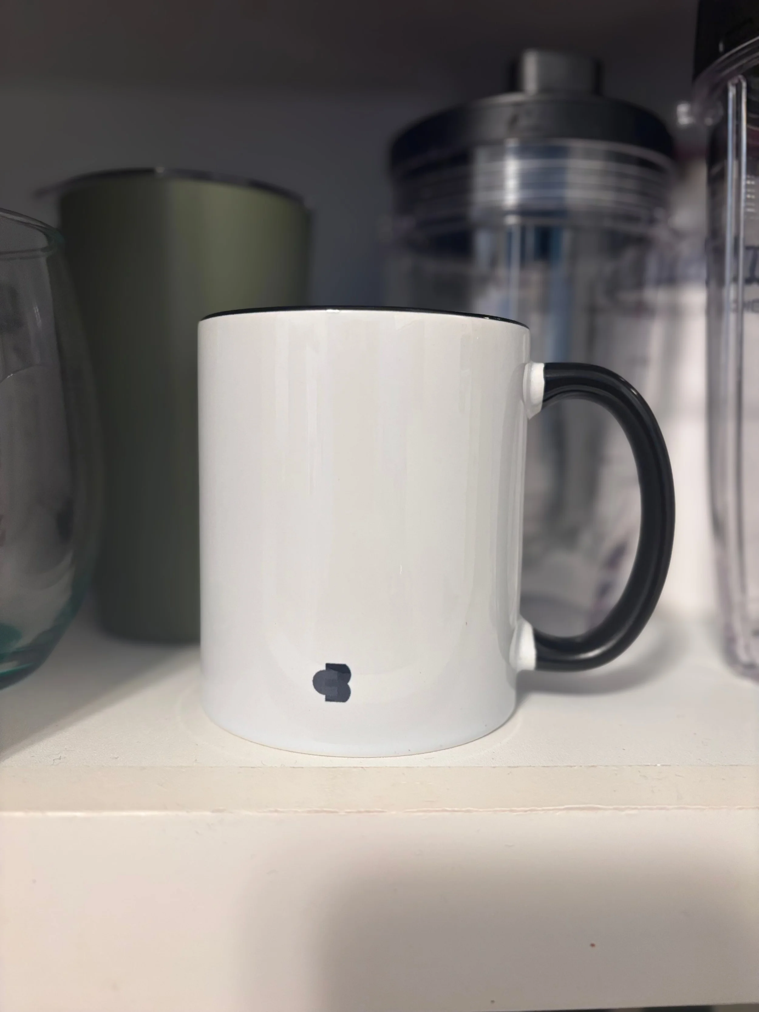 White ceramic mug with black handle and Cyber Boss™ monogram logo on the back
