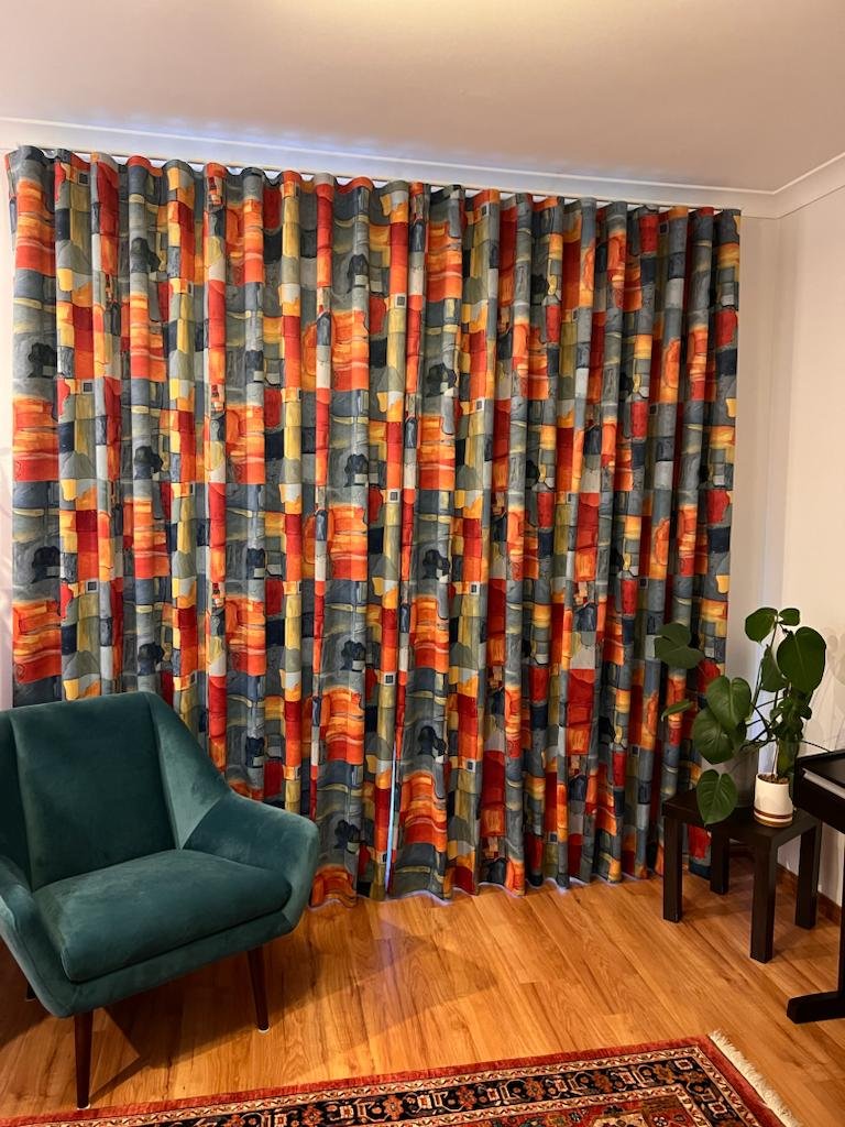 Colourful room with multi coloured drapes and velvet sofa