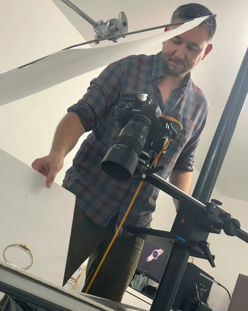 A photograph of Tom MacDonald of TomMac photography, on set shooting a watch in his Brisbane studio.