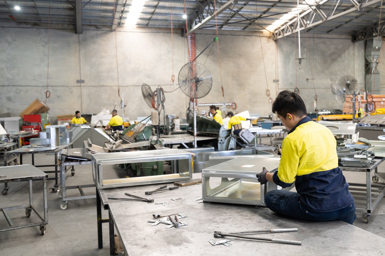 A commercial image of a worker fabricating ducting in Brisbane
