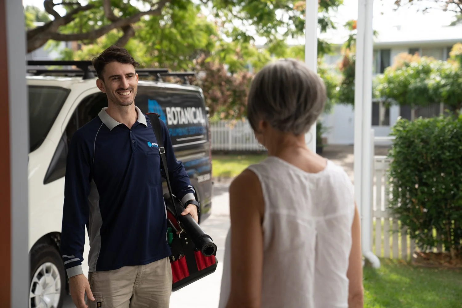 A commercial photograph of a plumber meeting his customer at their door. Taken in Brisbane by Tom MacDonald
