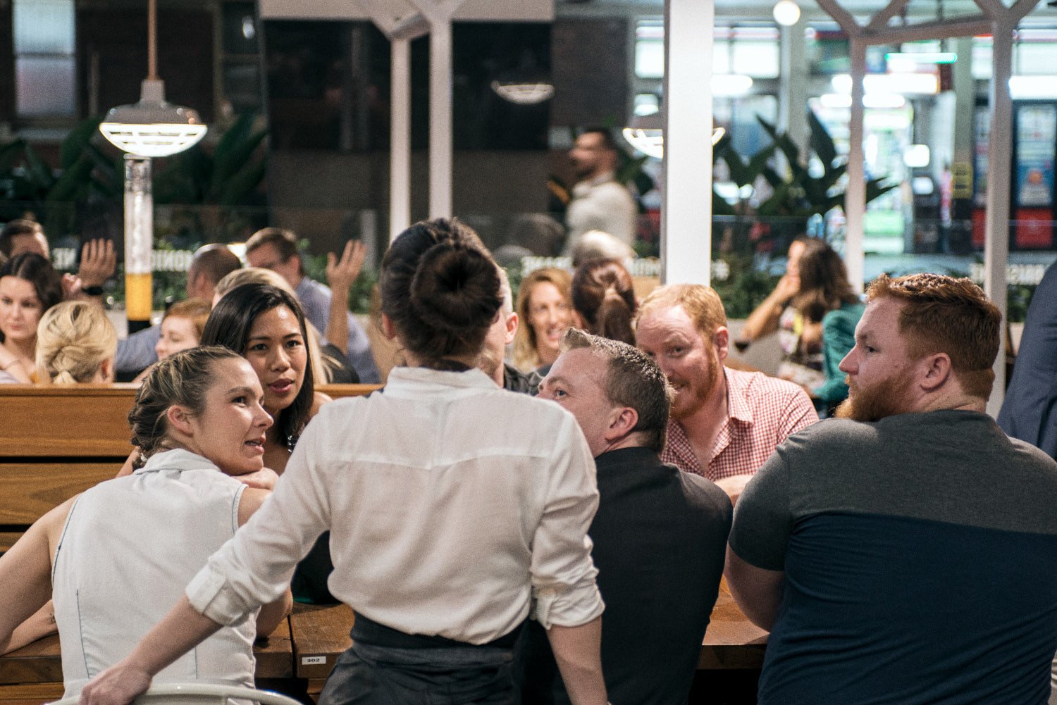 A commercial photo of people enjoying themselves at a restaurant. Taken by food photographer Tom MacDonald of Tom Mac photography.