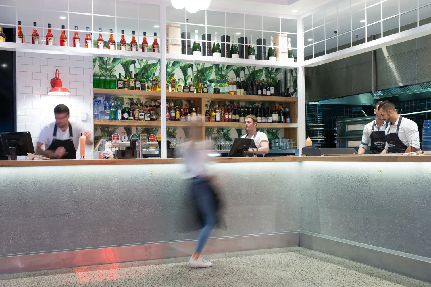 A commercial photo of a bar counter with three staff members working behind it, taken by Brisbane based commercial photographer Tom MacDonald. 