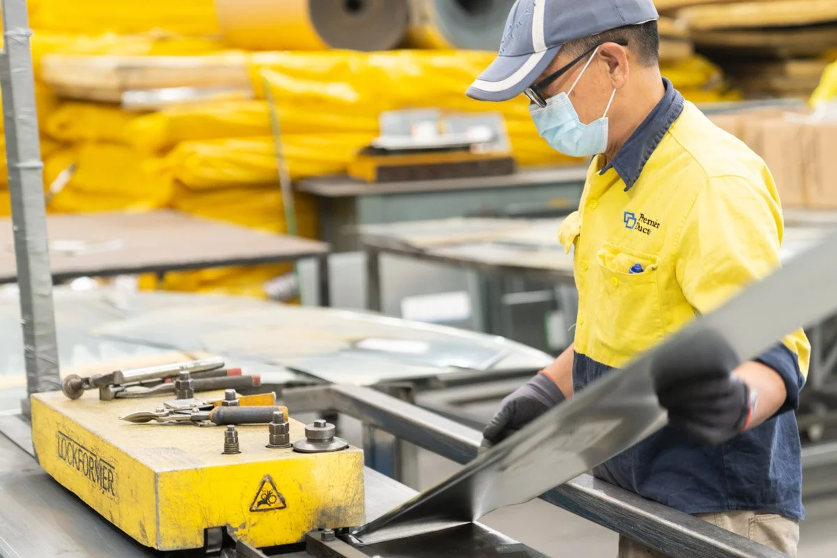 A commercial photograph of an industrial worker in a Brisbane metal fabrication workshop, taken by commercial photographer Tom MacDonald of Tom Mac photography