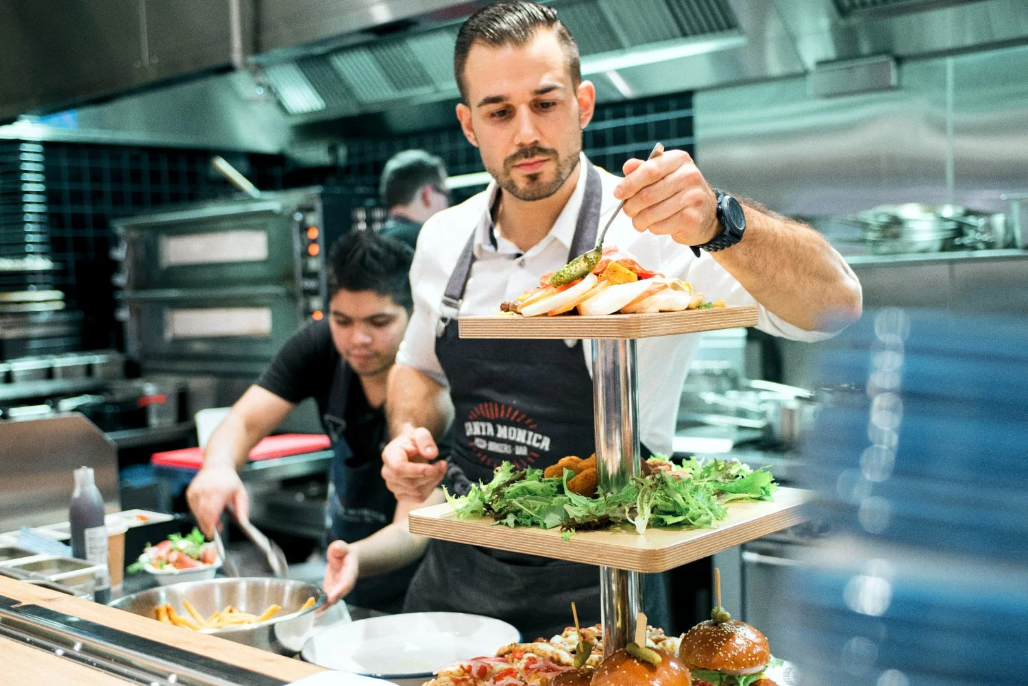 A commercial image of a chef preparing food in a professional kitchen, taken by Brisbane based commercial photographer Tom MacDonald.