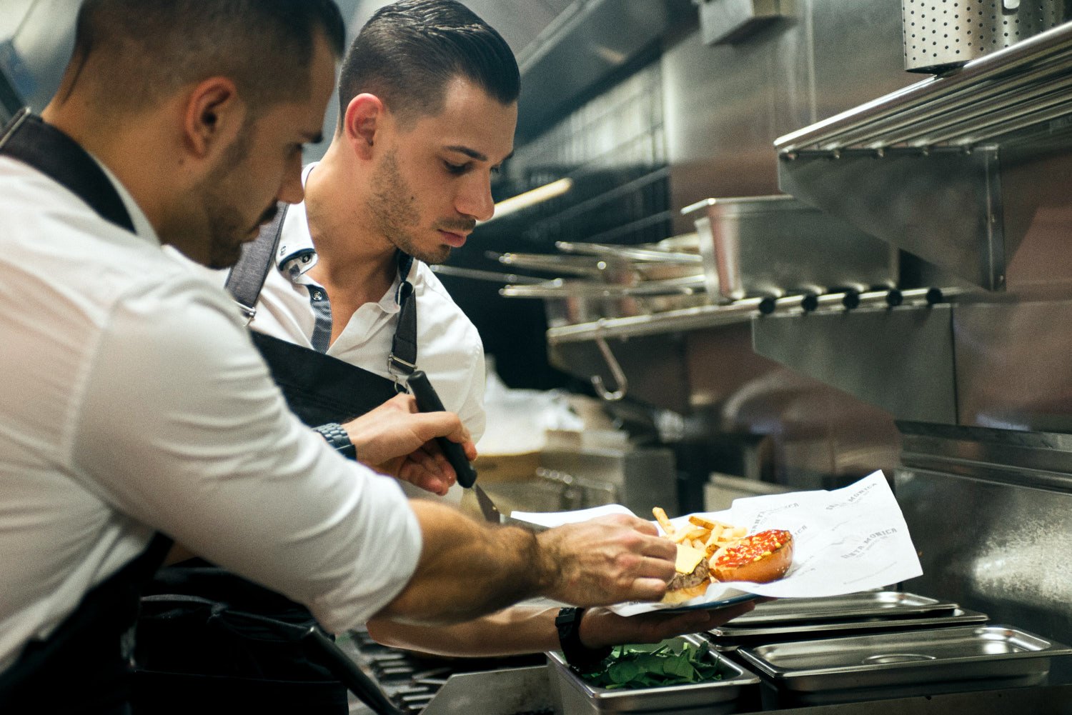 A commercial photo of two chefs, in a professional kitchen. Taken by Brisbane based food photographer Tom MacDonald of Tom Mac photography.