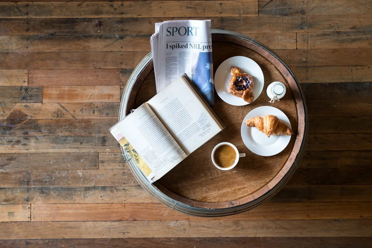 A commercial lifestyle image showing a top-down view of a round wooden table on a wooden floor. Taken by Brisbane commercial photographer Tom MacDonald. 