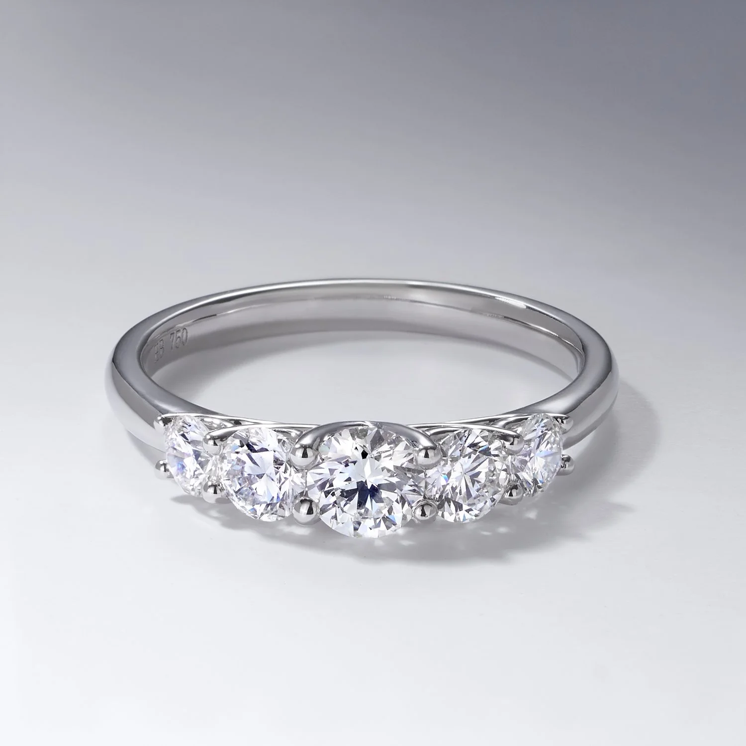 A silver ring with five large, round, clear gemstones set in a row. taken for HArdy brothers jewellers in Brisbane by commercial jewellery photographer Tom MacDonald of Tom Mac photography.