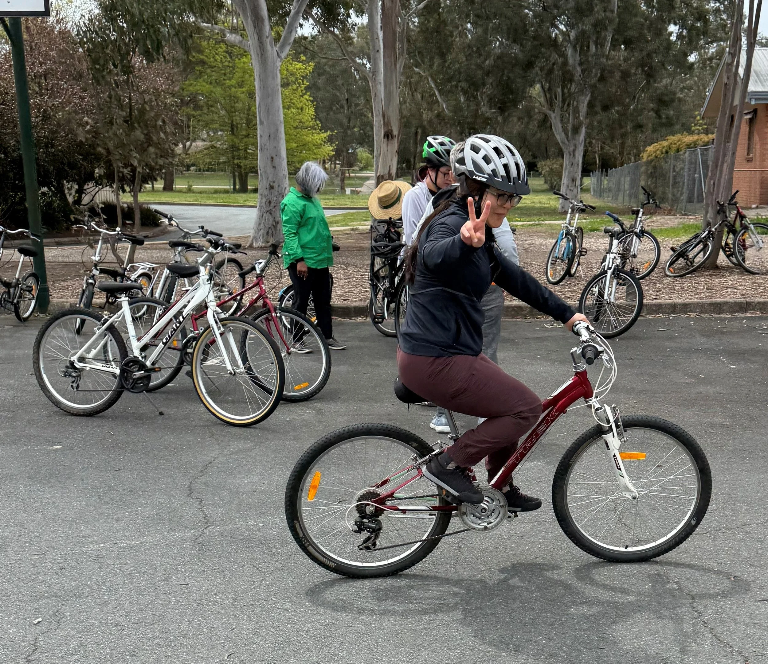 A Cycle Well learner riding a bike with a group nearby