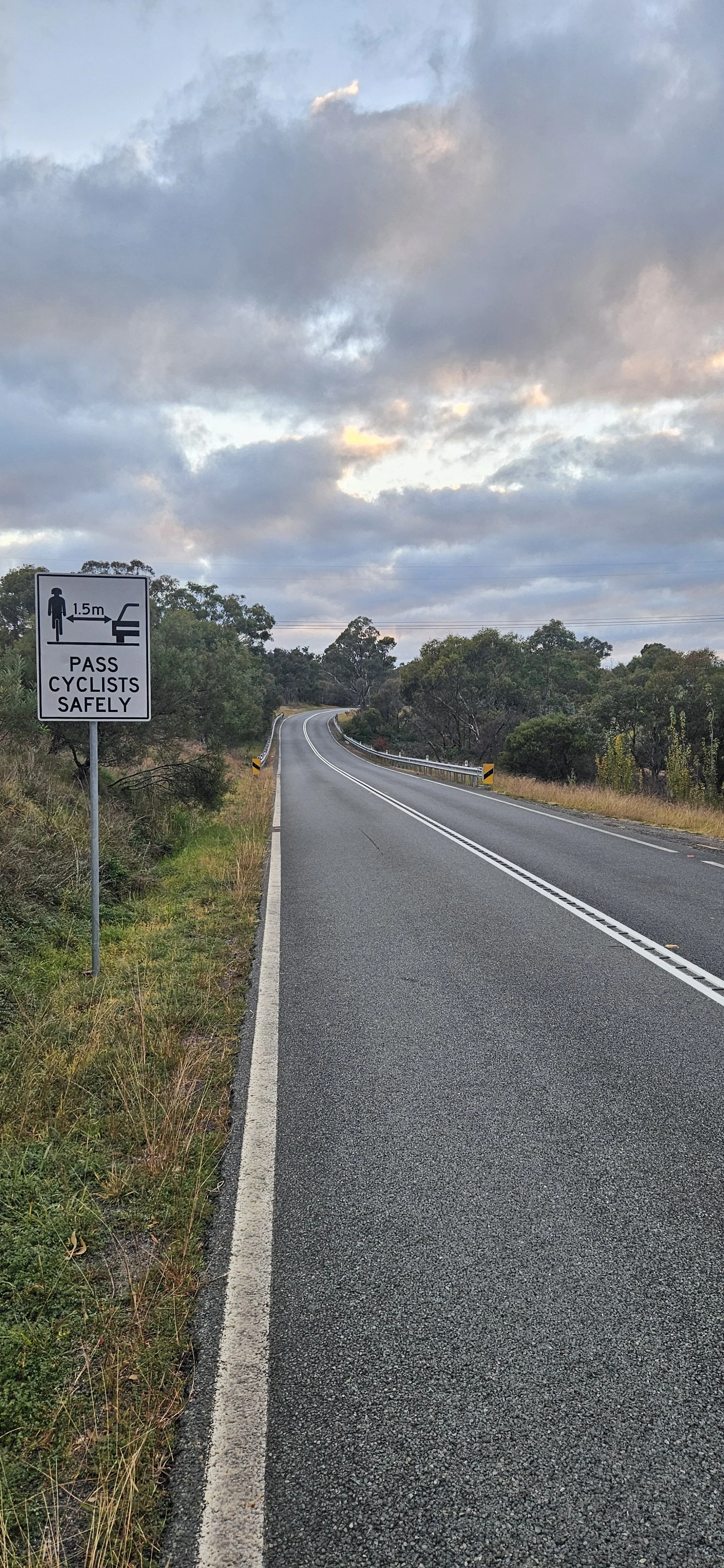 Cotter Road with a roadside sign asking motorists to pass cyclists safely